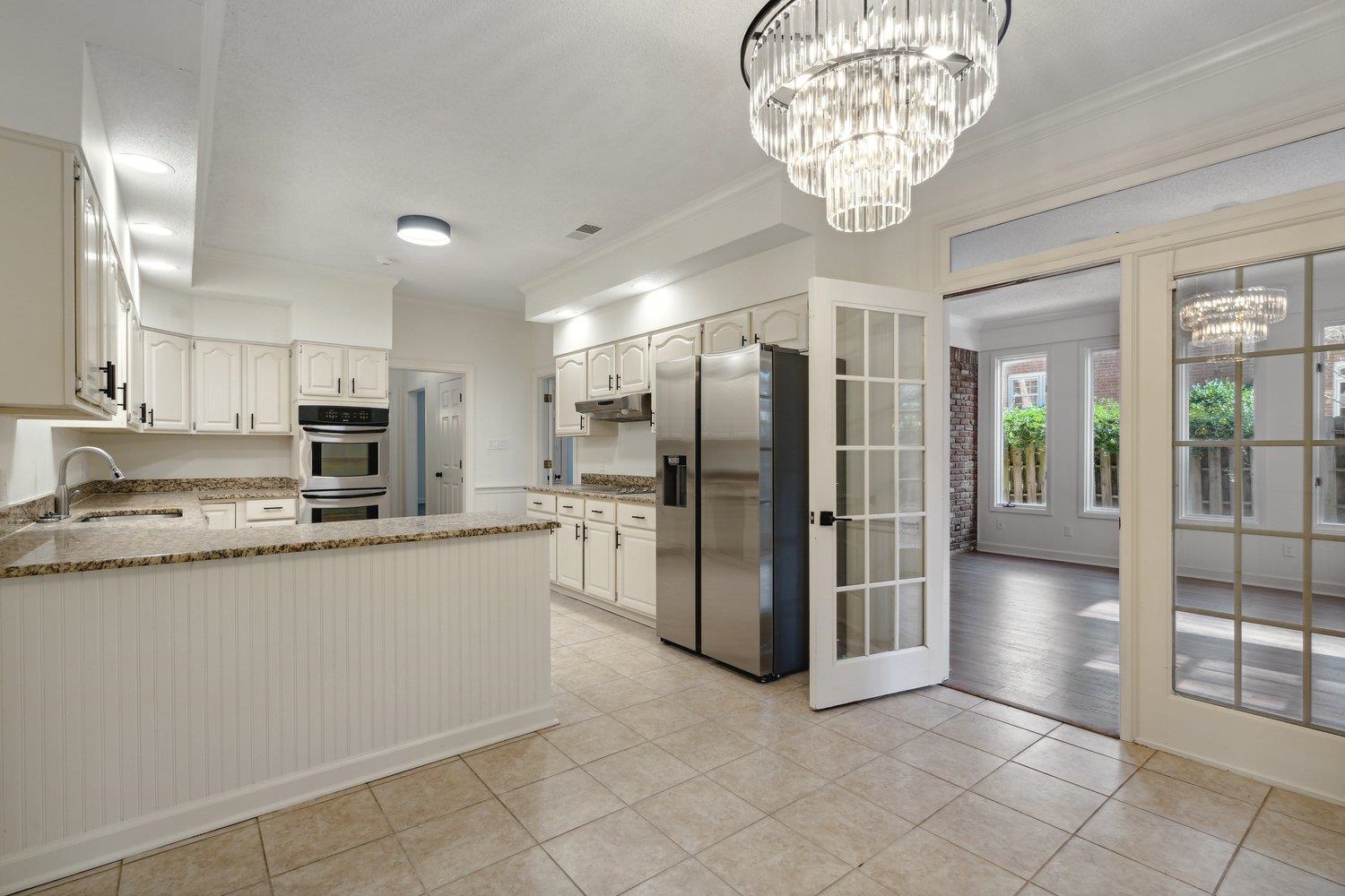 Kitchen with crown molding, sink, white cabinetry, and appliances with stainless steel finishes