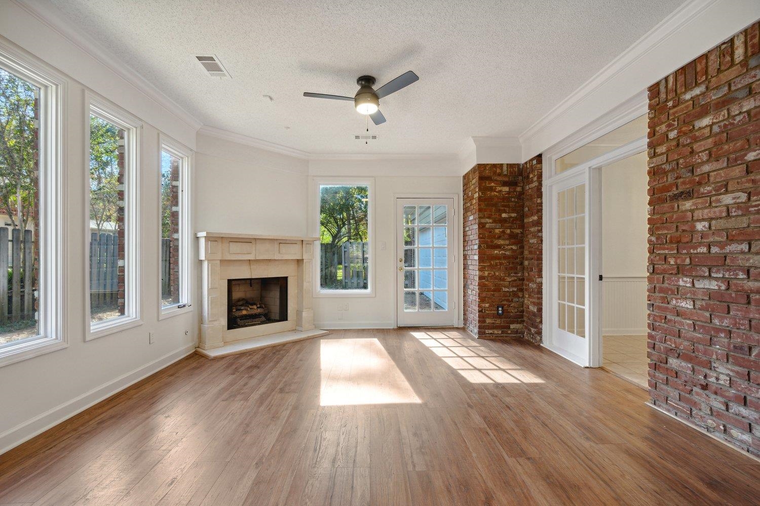 Unfurnished living room with ceiling fan, hardwood / wood-style flooring, and a healthy amount of sunlight