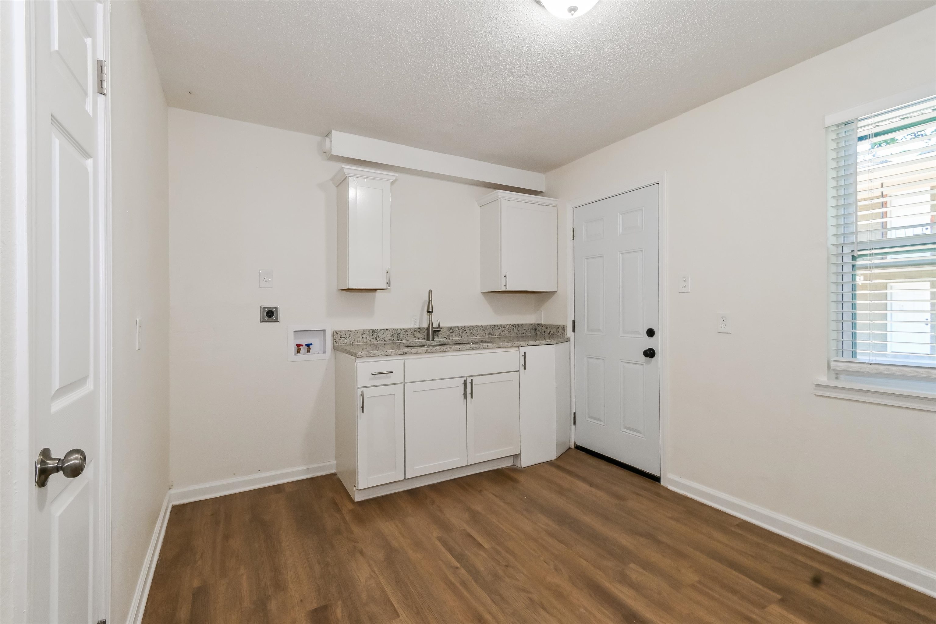 Kitchen featuring white cabinets, a textured ceiling, sink, and dark hardwood / wood-style flooring