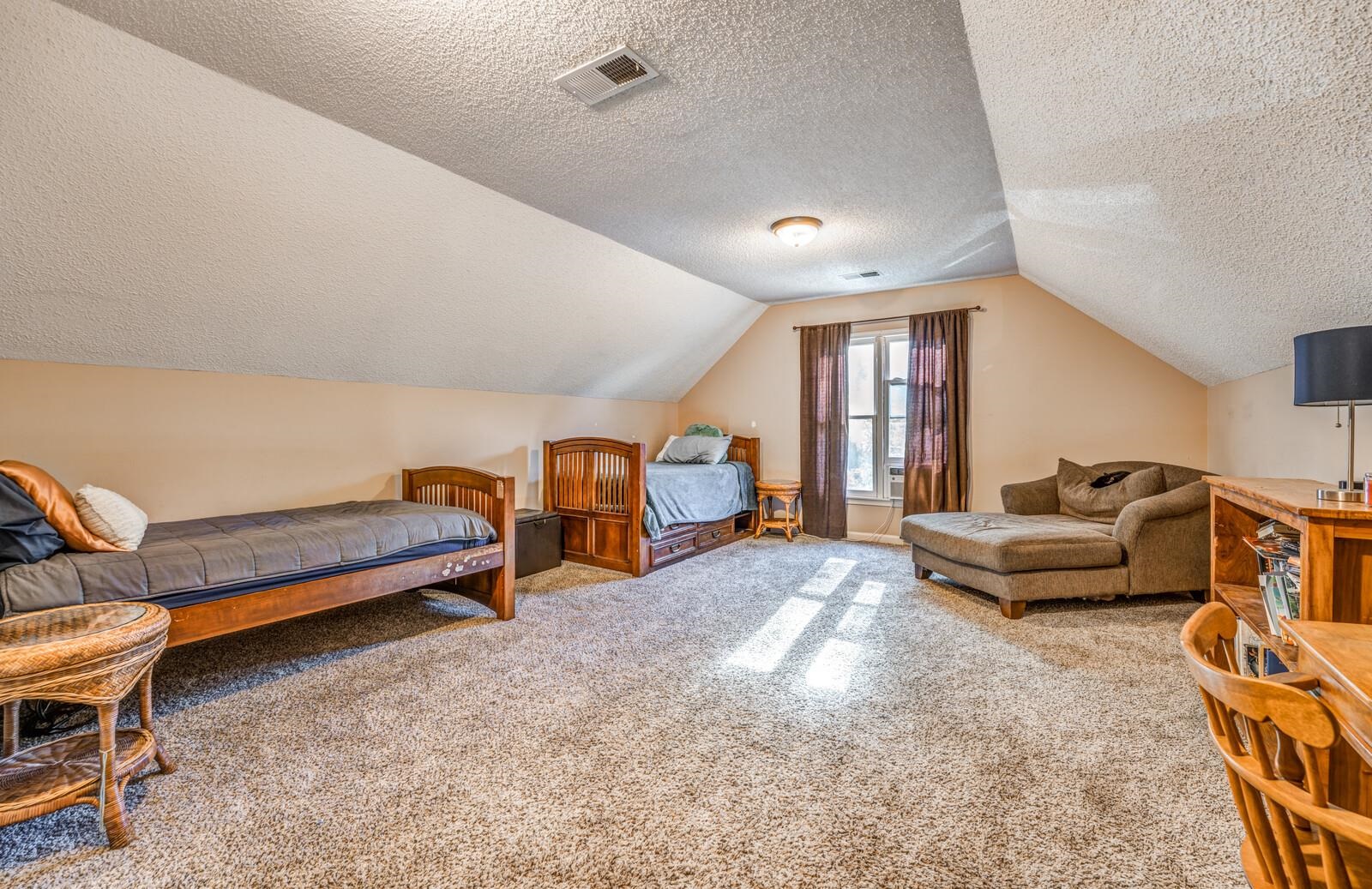 Carpeted bedroom with lofted ceiling and a textured ceiling