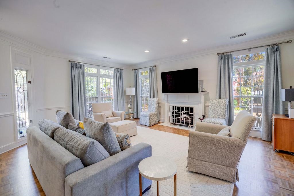 Living room featuring ornamental molding, a wealth of natural light, and light parquet floors