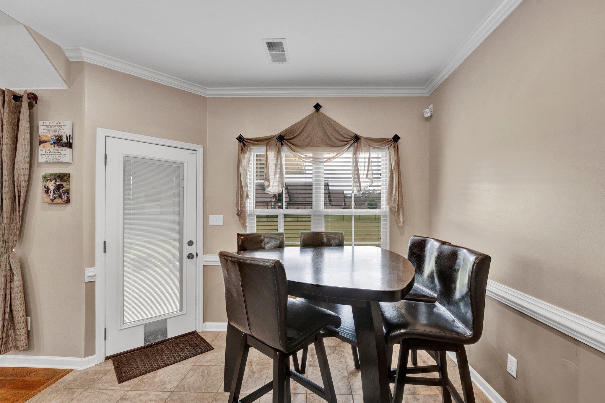 Tiled dining room with crown molding