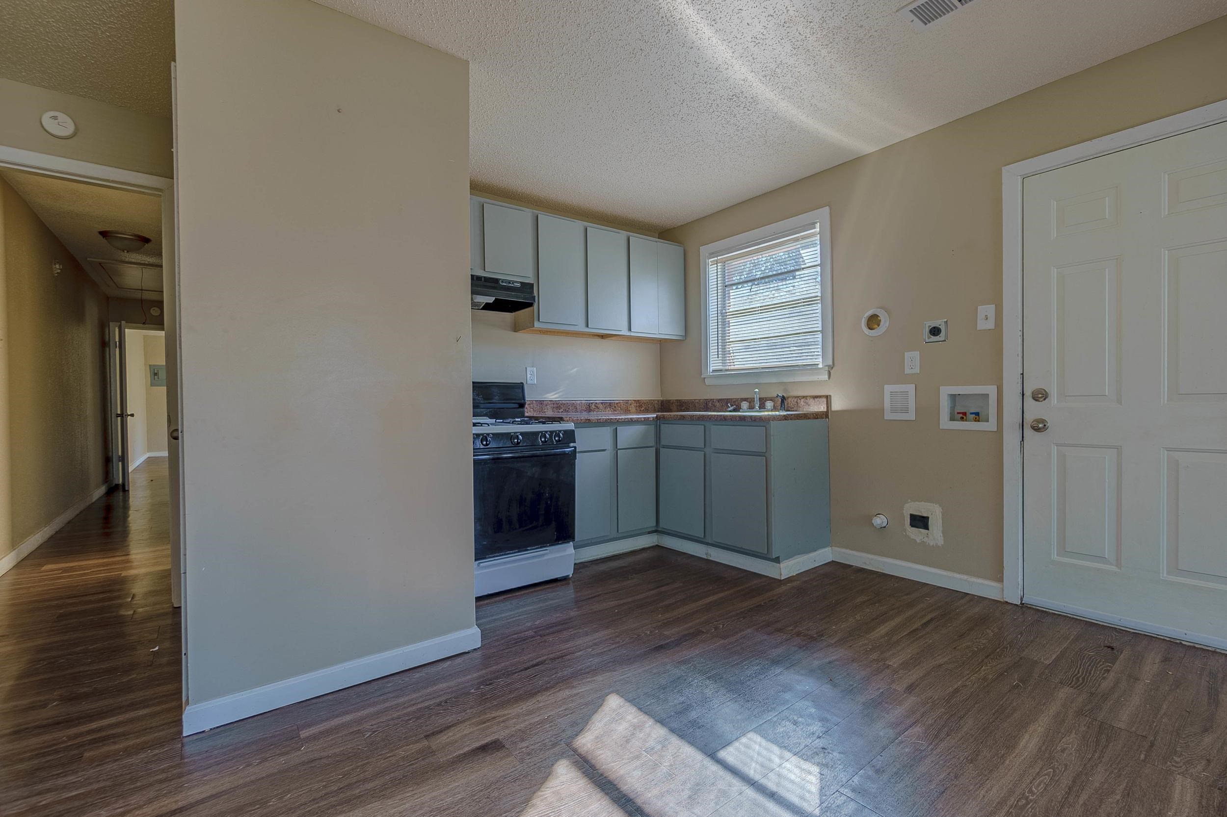 Kitchen with dark hardwood / wood-style flooring, white gas range, a textured ceiling, and extractor fan