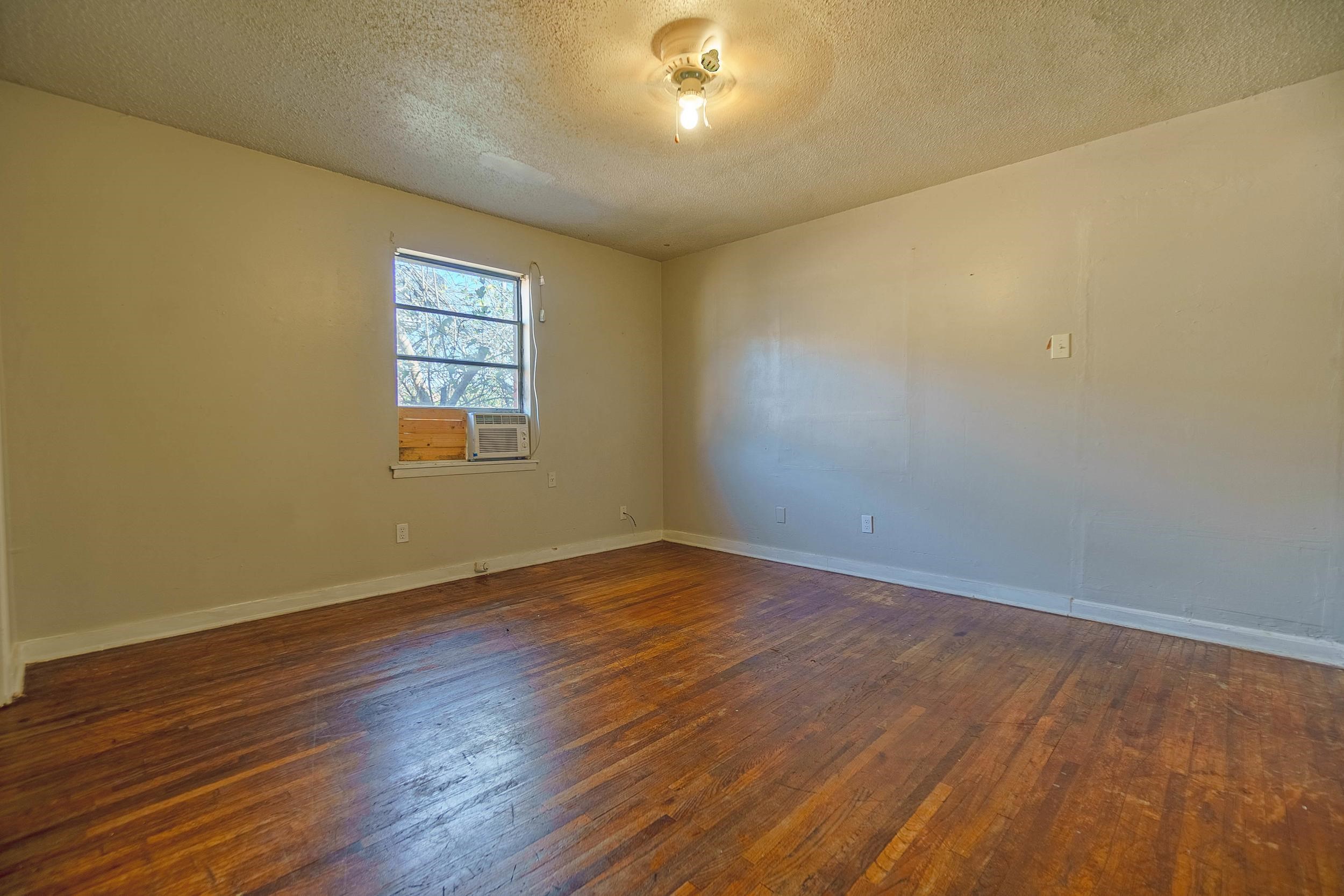 Unfurnished room featuring ceiling fan, a textured ceiling, and dark wood-type flooring