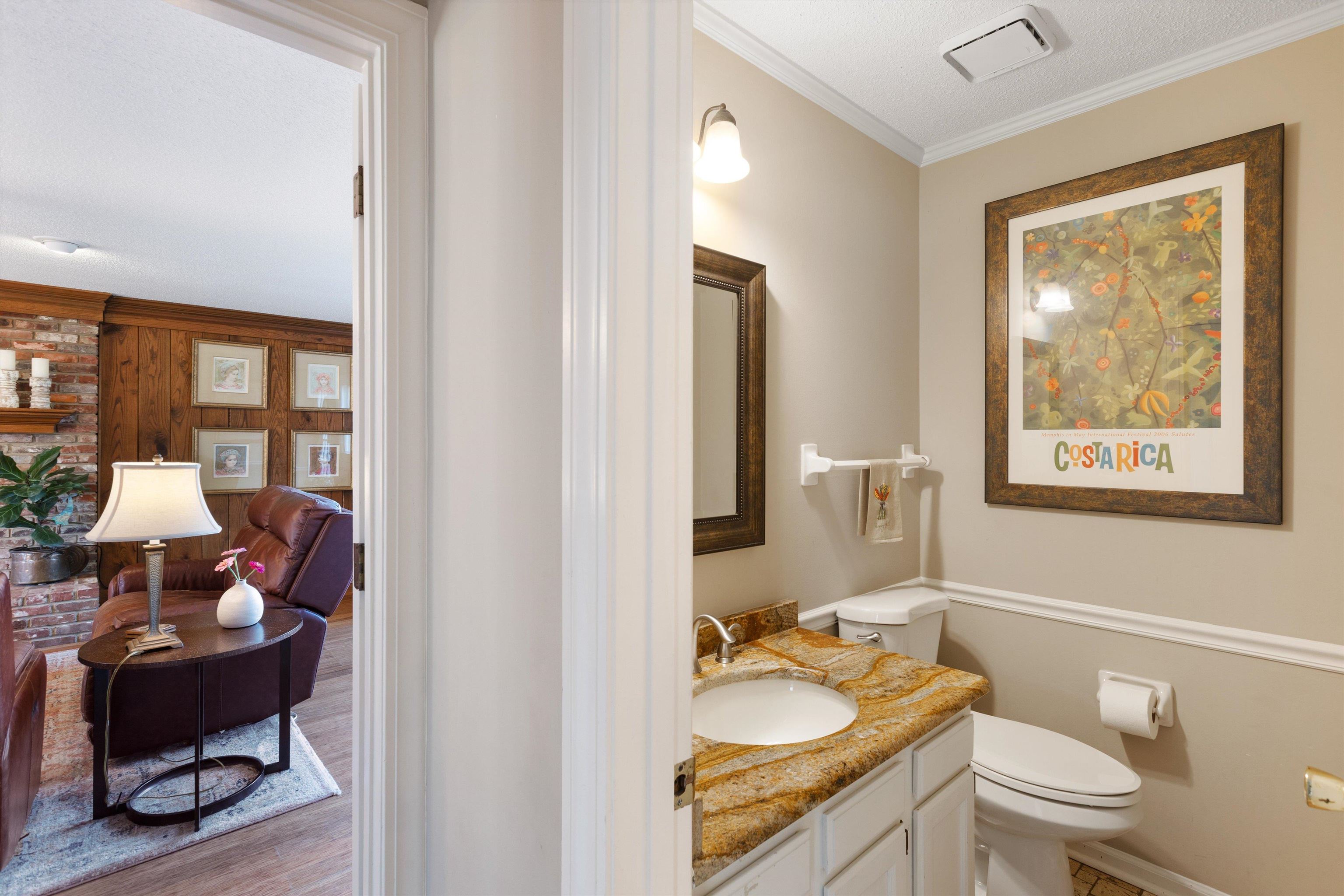 Bathroom with crown molding, a textured ceiling, toilet, vanity, and hardwood / wood-style flooring