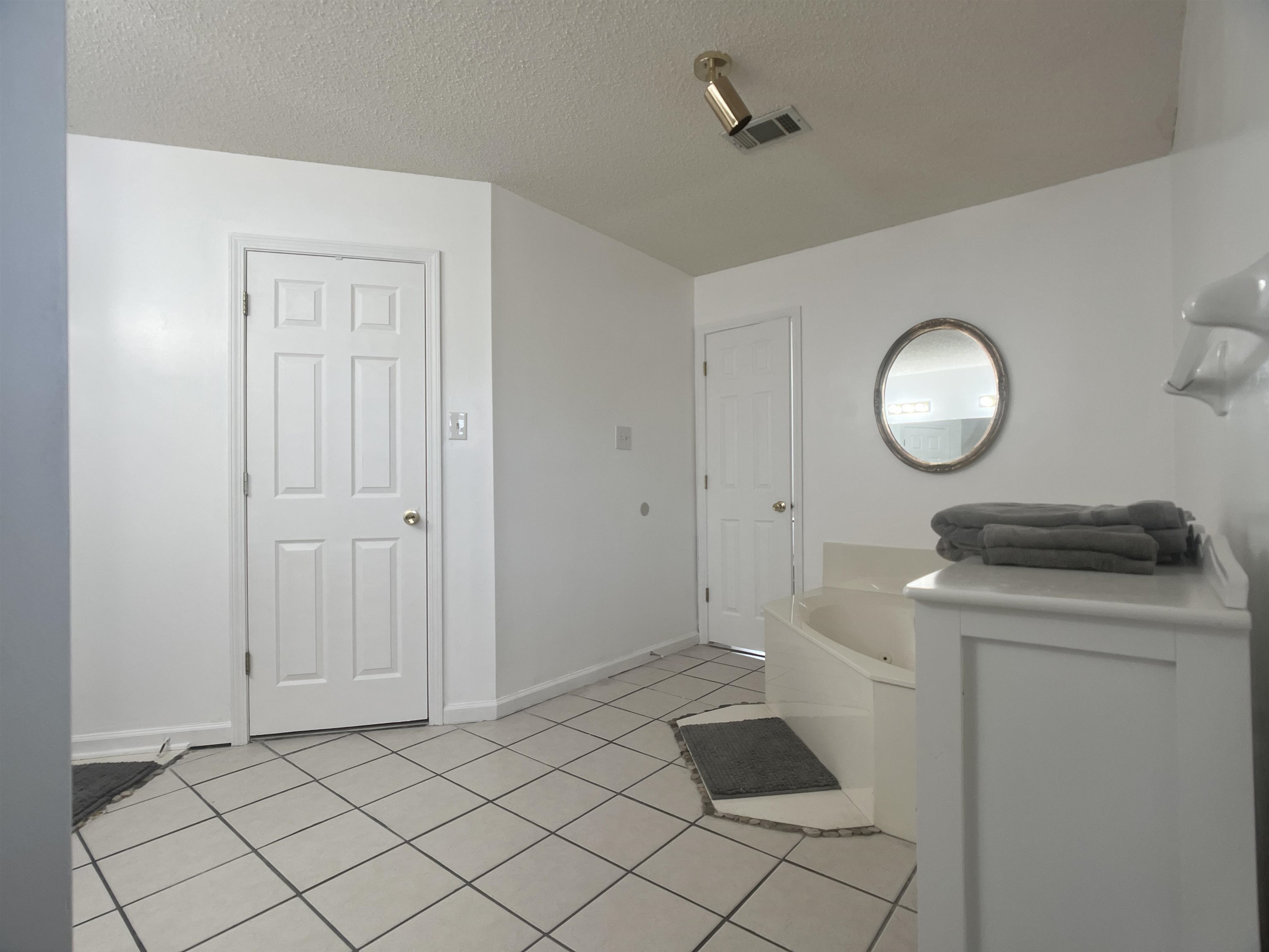 Bathroom featuring a textured ceiling, tile patterned floors, and a bathtub