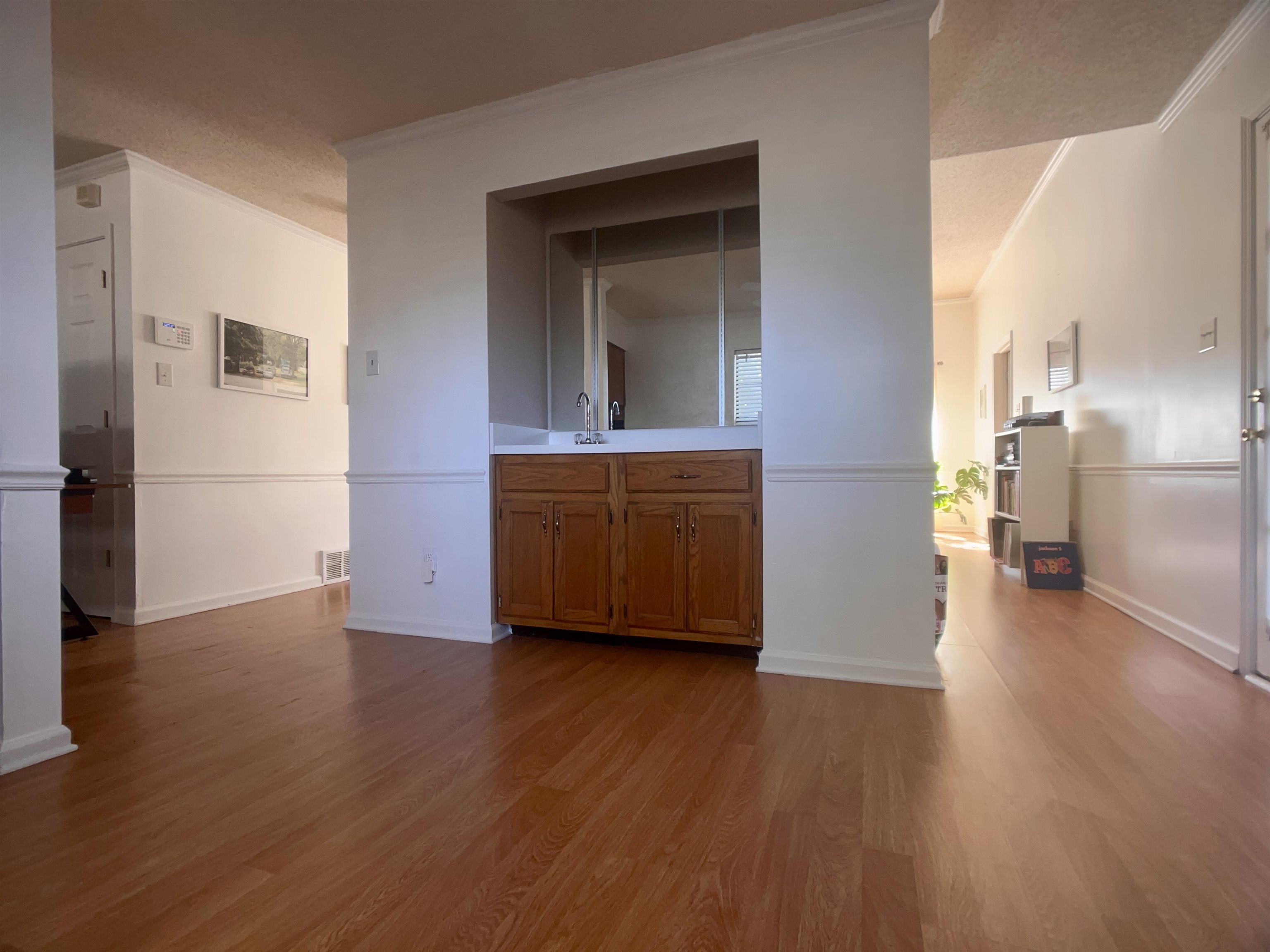 Interior space with sink, light hardwood / wood-style flooring, and ornamental molding