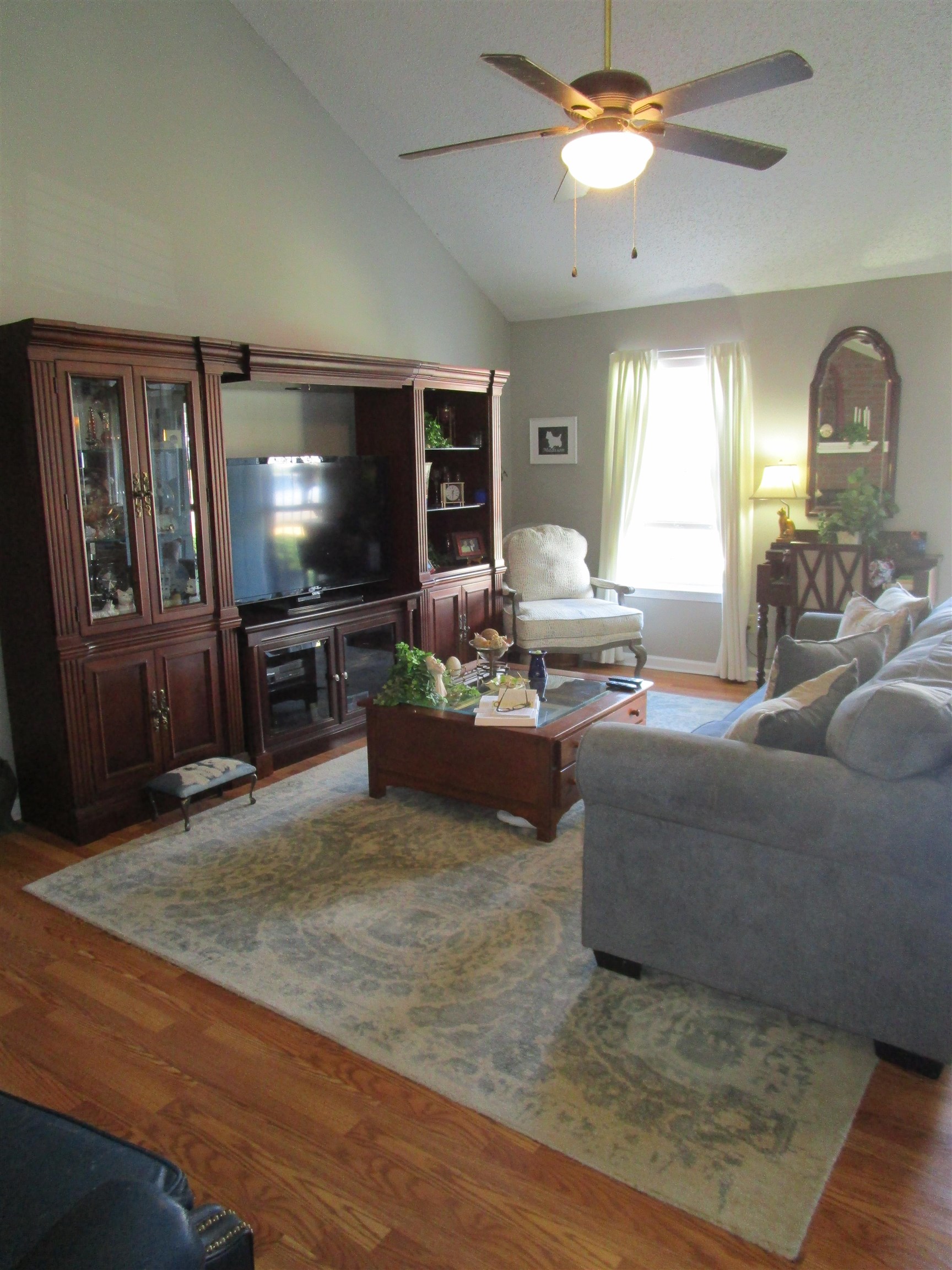 Living room with ceiling fan, wood-type flooring, and lofted ceiling Large room 20x14