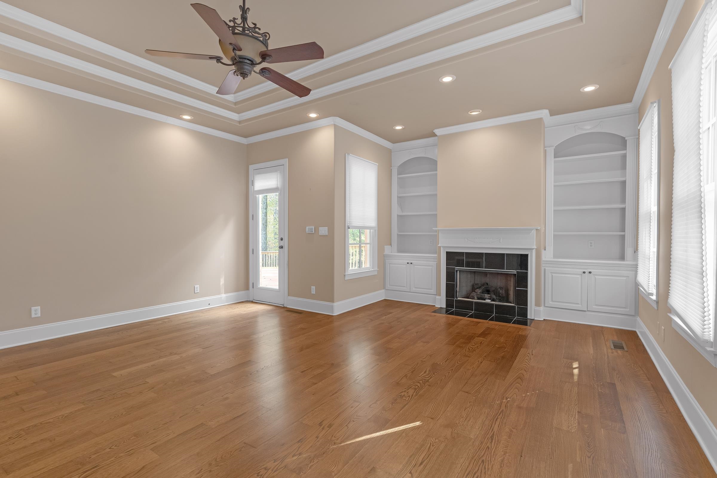 Another view of the primary bedroom with the tray ceiling and recessed lighting