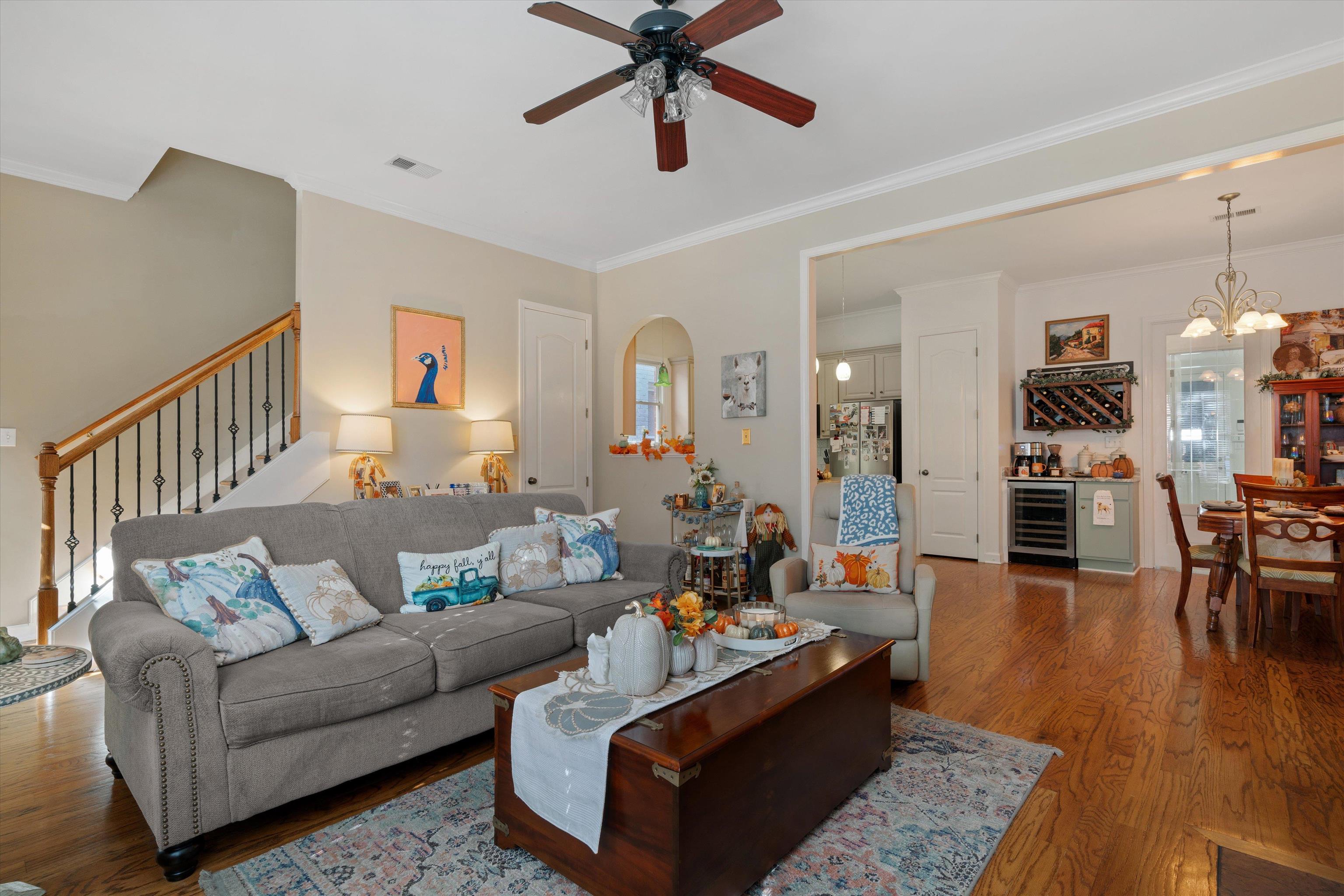 Living room featuring hardwood  ornamental molding, ceiling fan