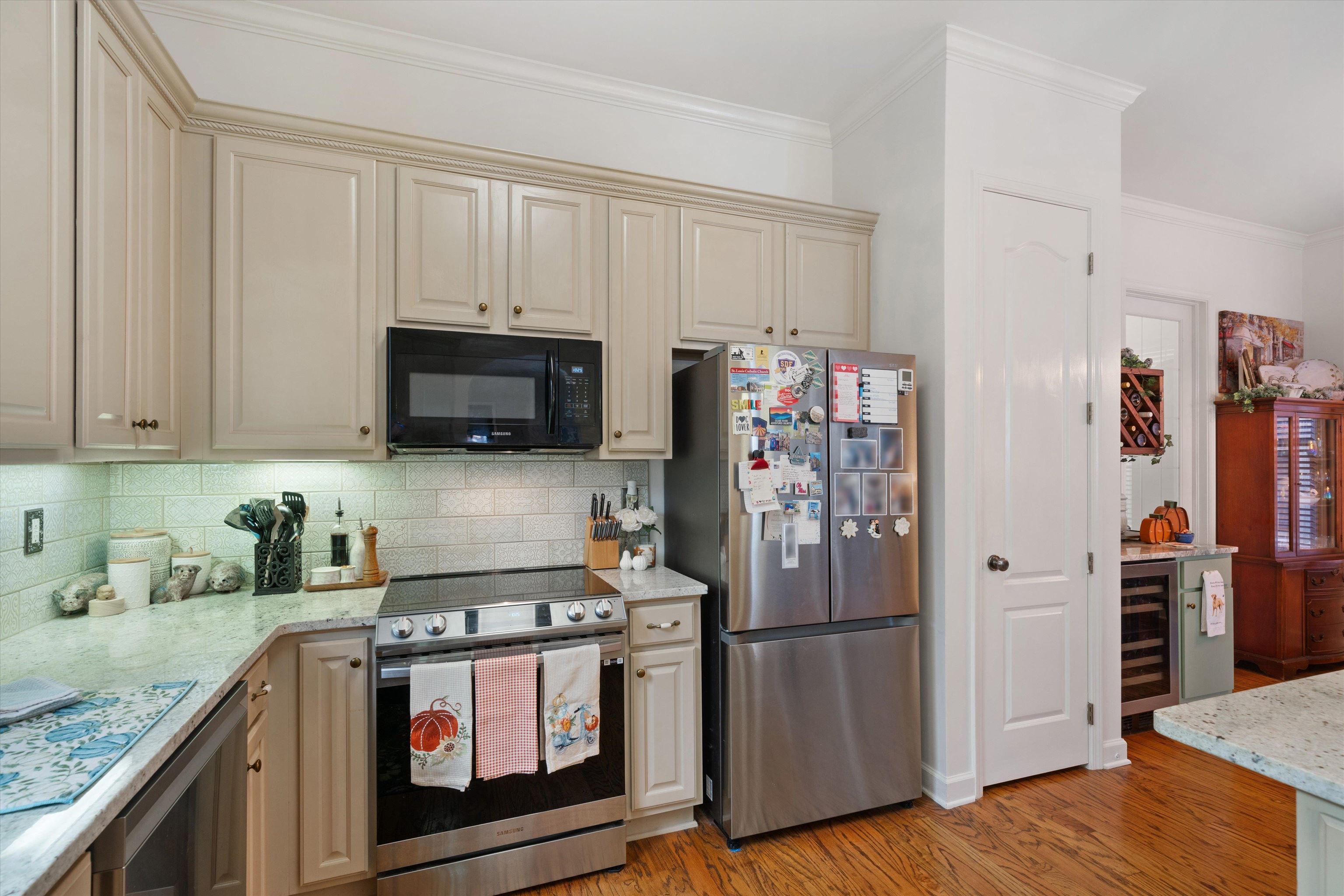 Kitchen featuring cream cabinetry, appliances with stainless steel finishes, hardwood floors