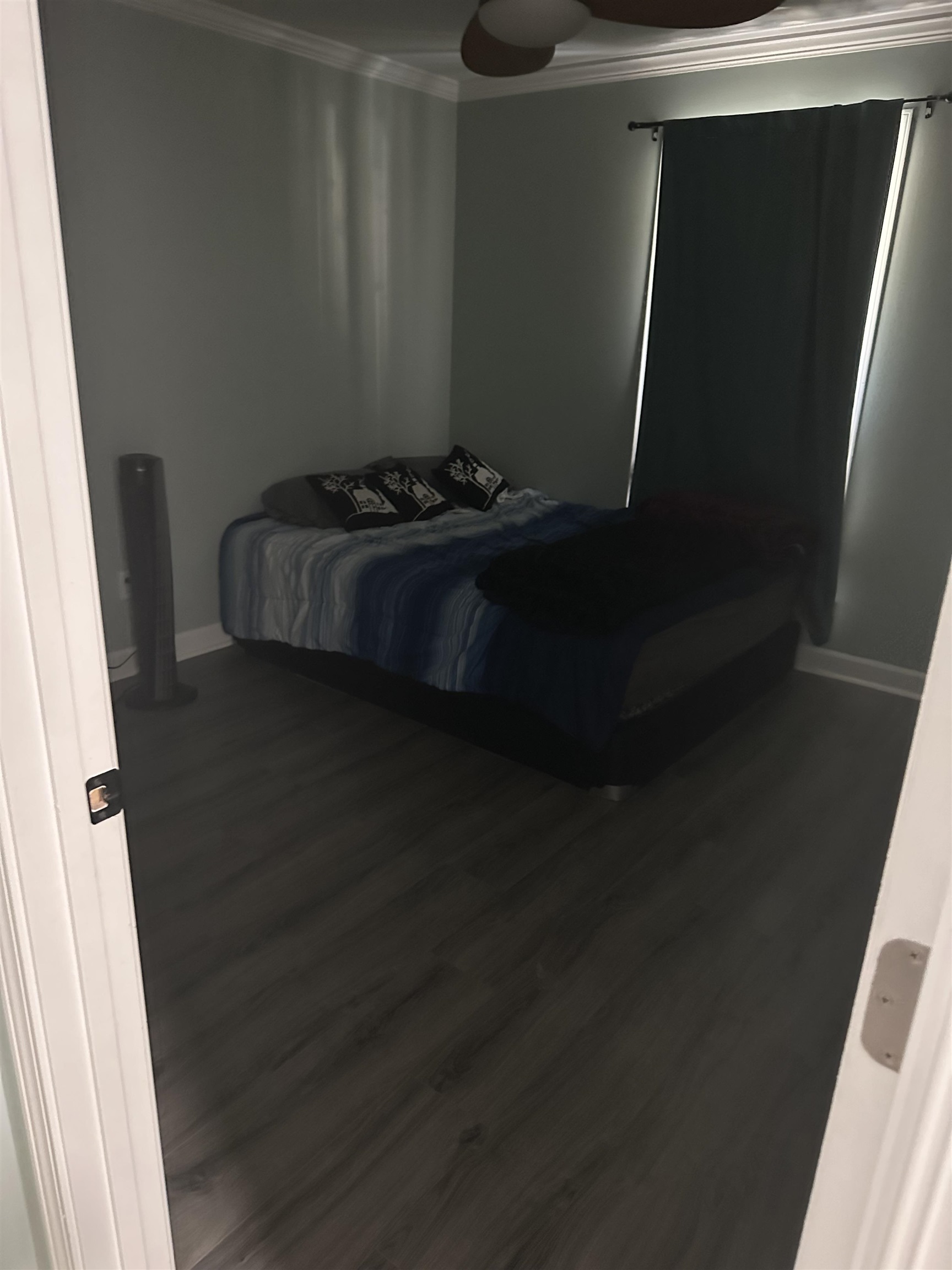 Bedroom featuring ornamental molding and dark wood-type flooring