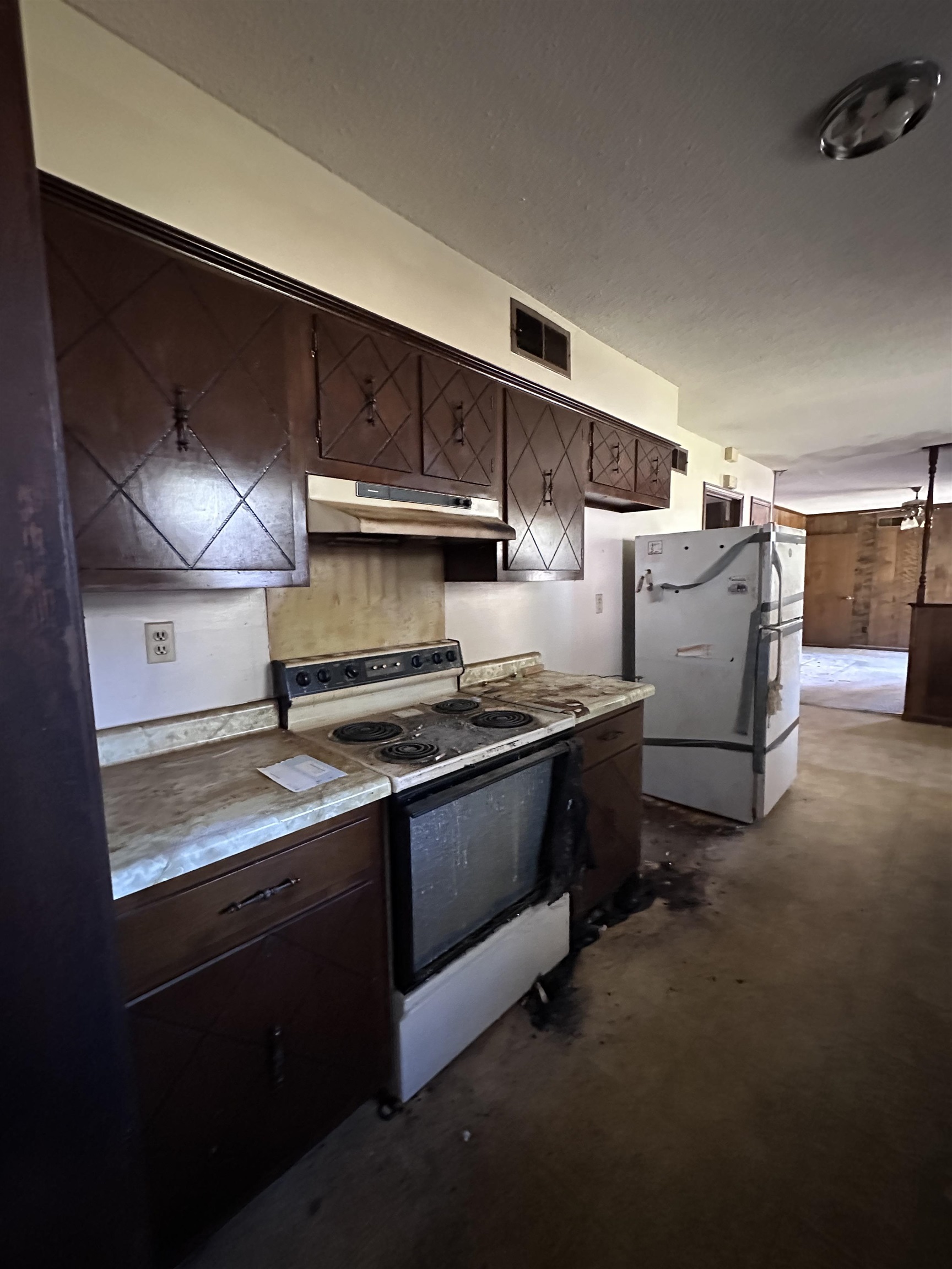 Kitchen featuring dark brown cabinets and white appliances