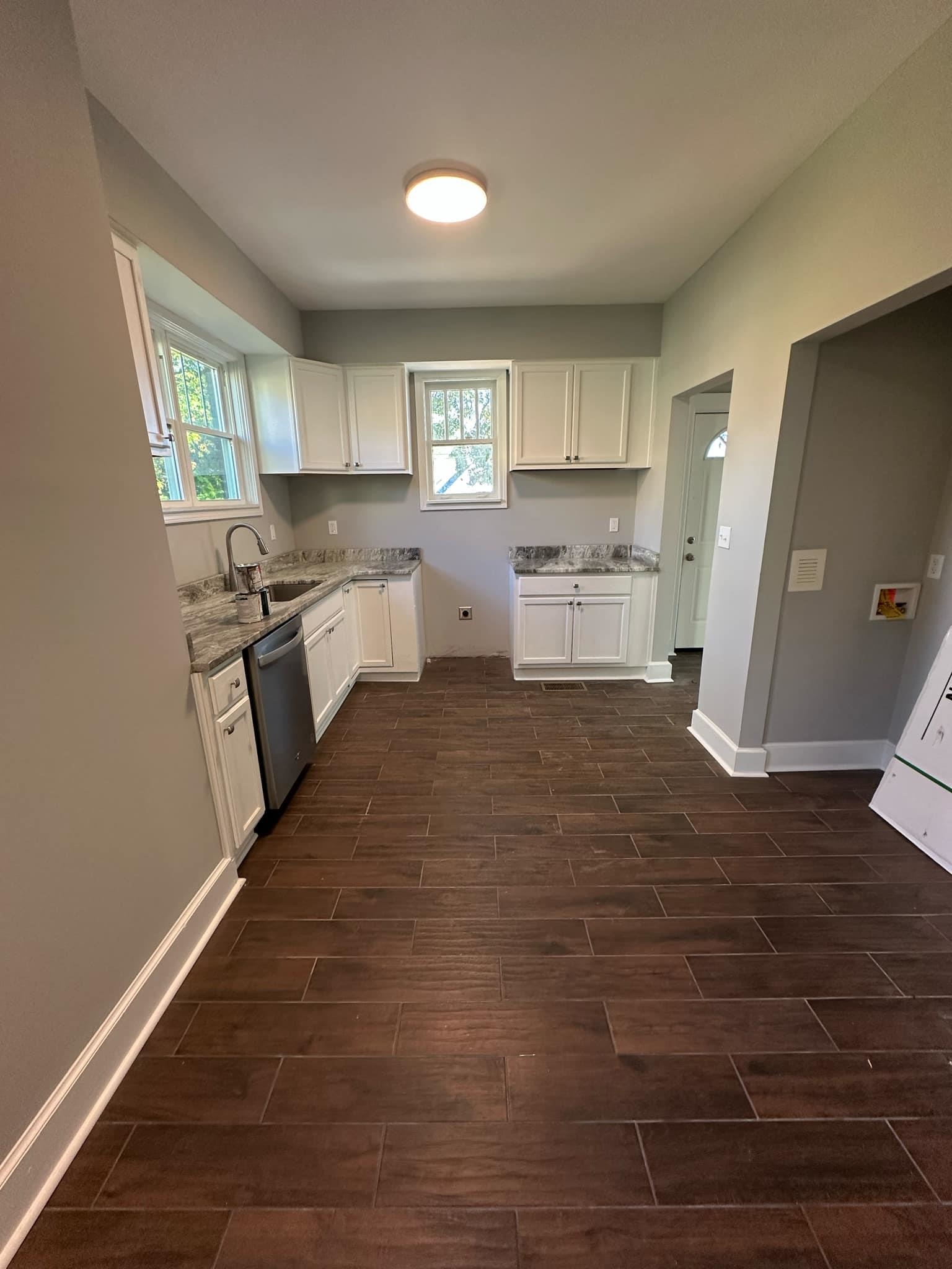 Kitchen featuring plenty of natural light, white cabinets, stainless steel dishwasher, and sink