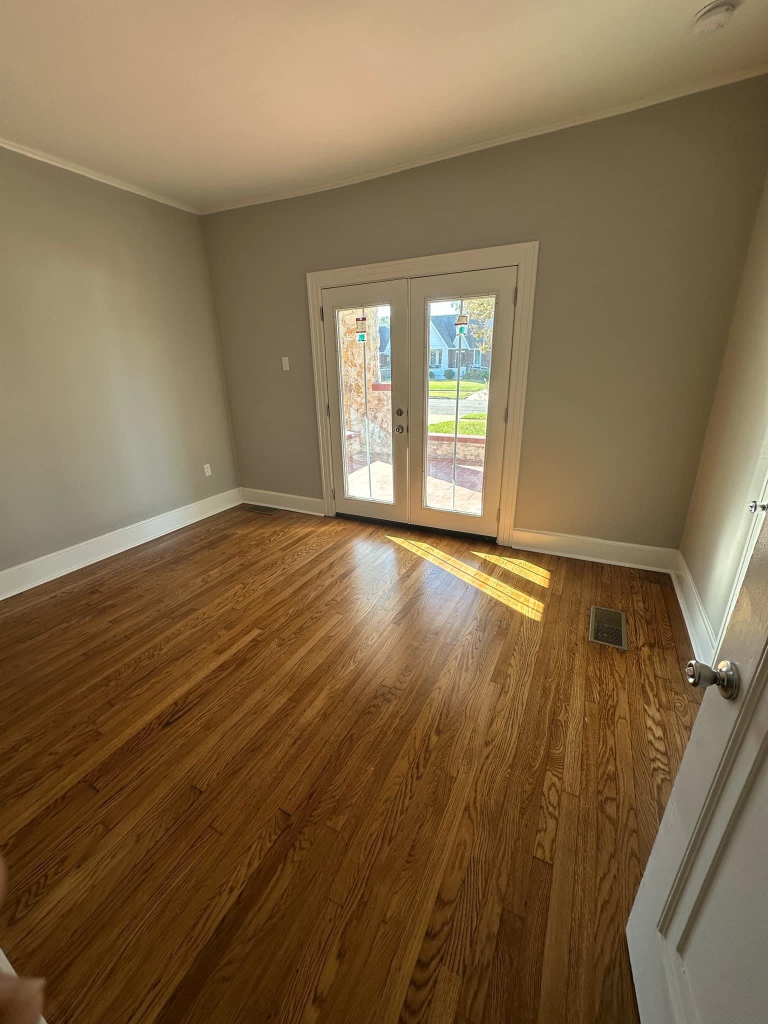 Unfurnished room featuring french doors and hardwood / wood-style flooring