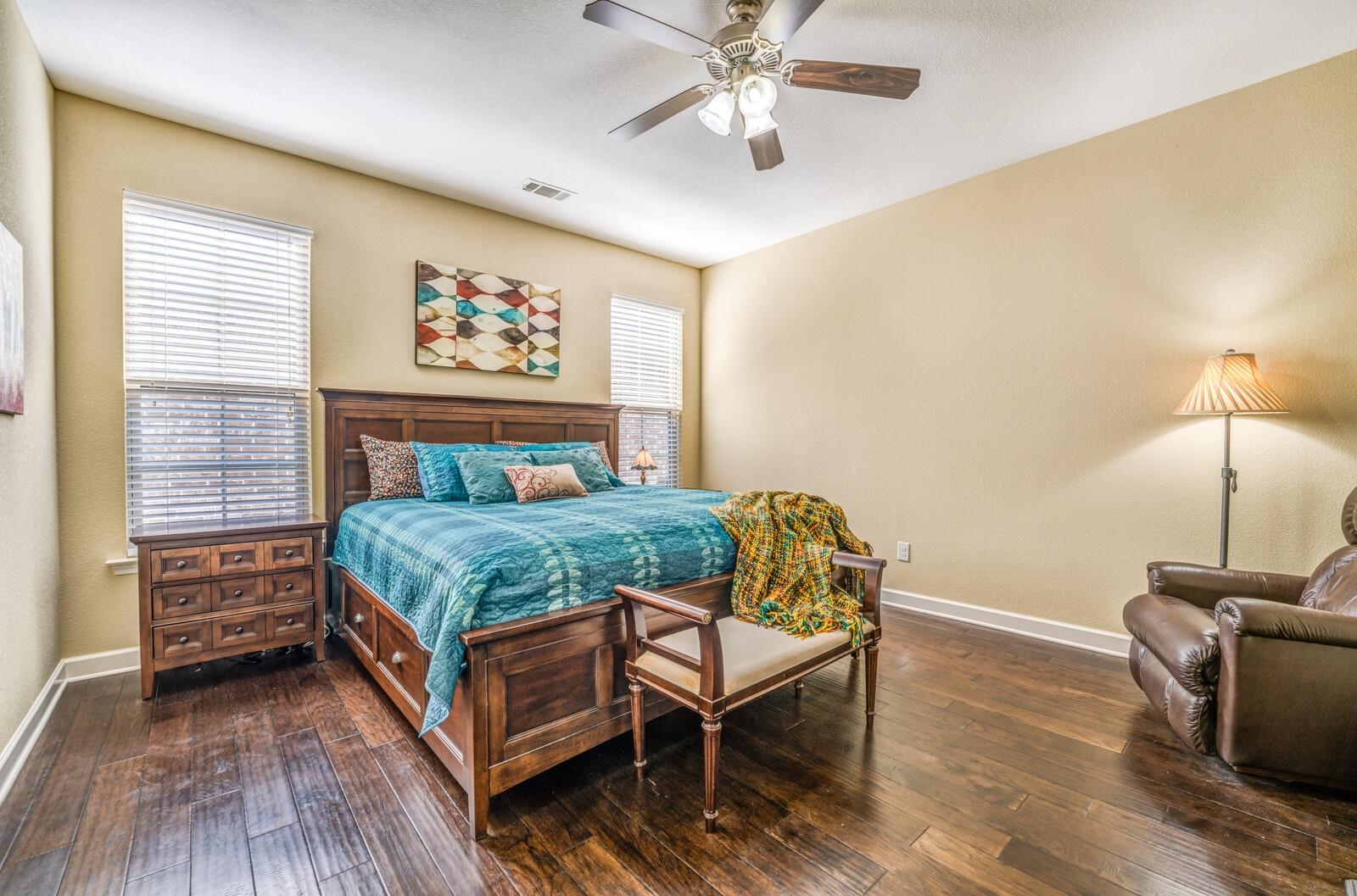 Bedroom with ceiling fan and dark wood-type flooring