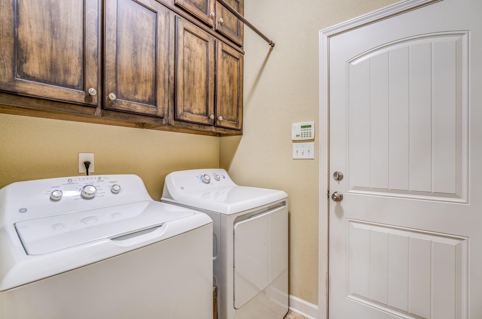 Laundry room featuring cabinets and washing machine and dryer