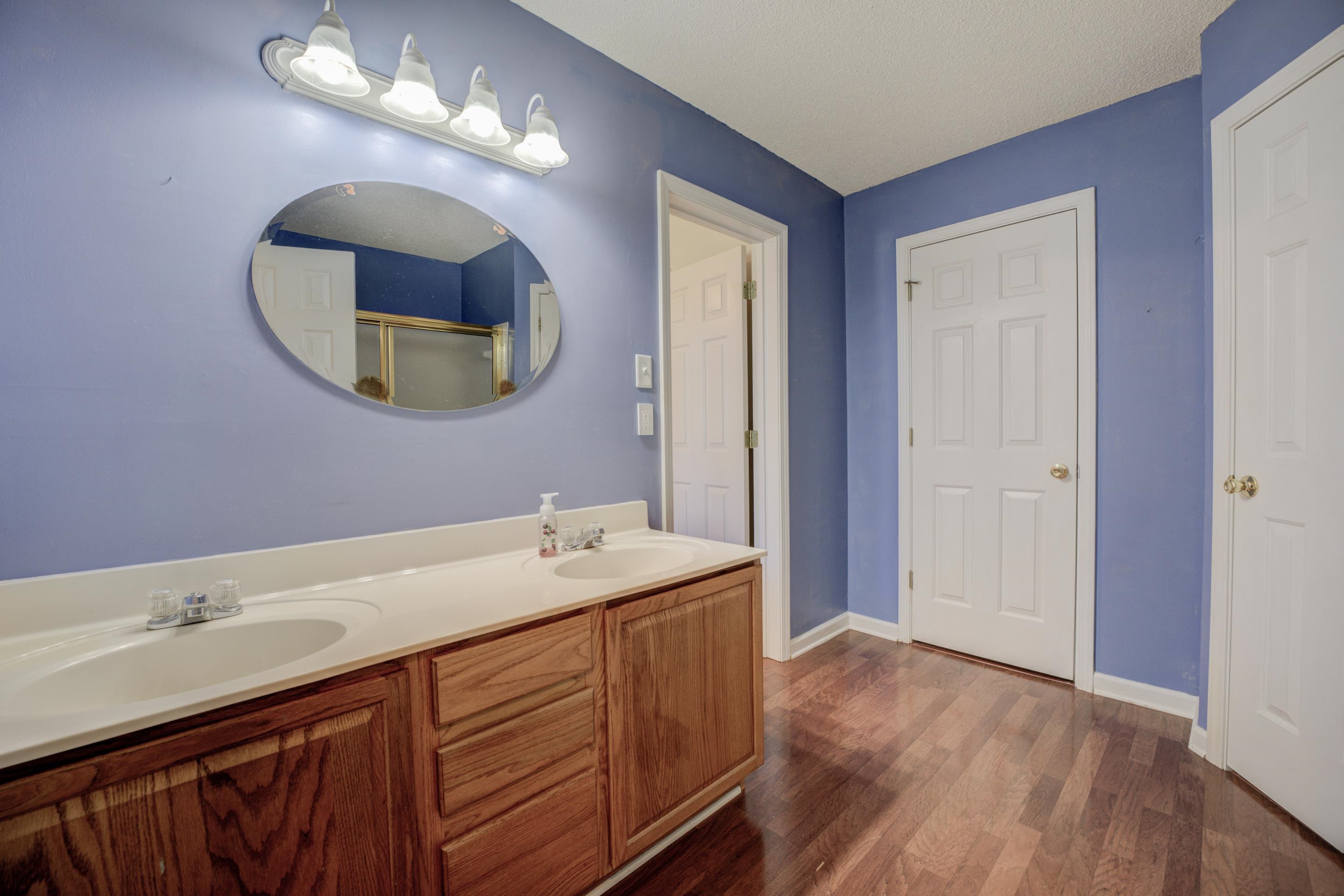 Bathroom with hardwood / wood-style floors, vanity, and a textured ceiling