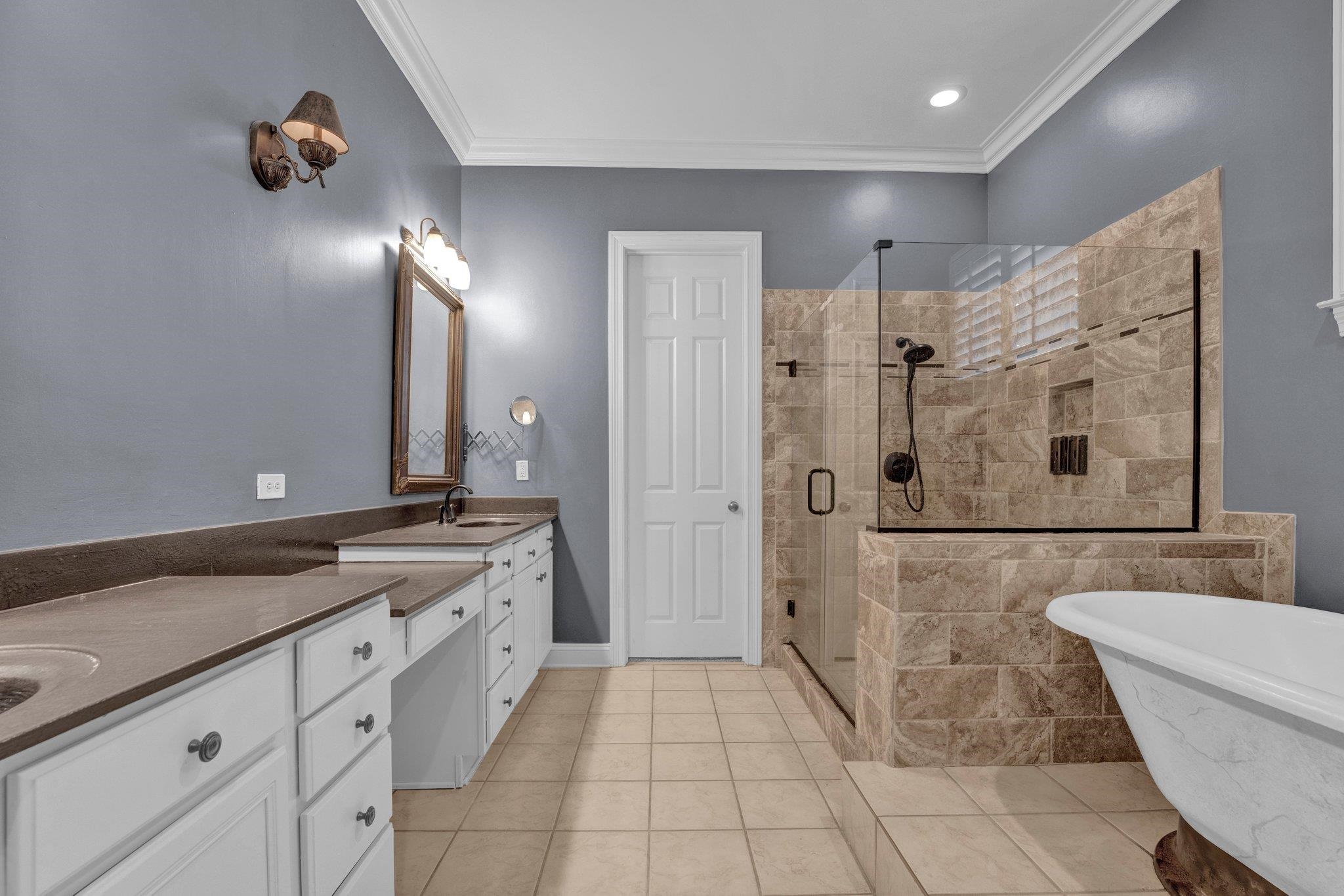 Bathroom featuring tile patterned flooring, vanity, separate shower and tub, and crown molding