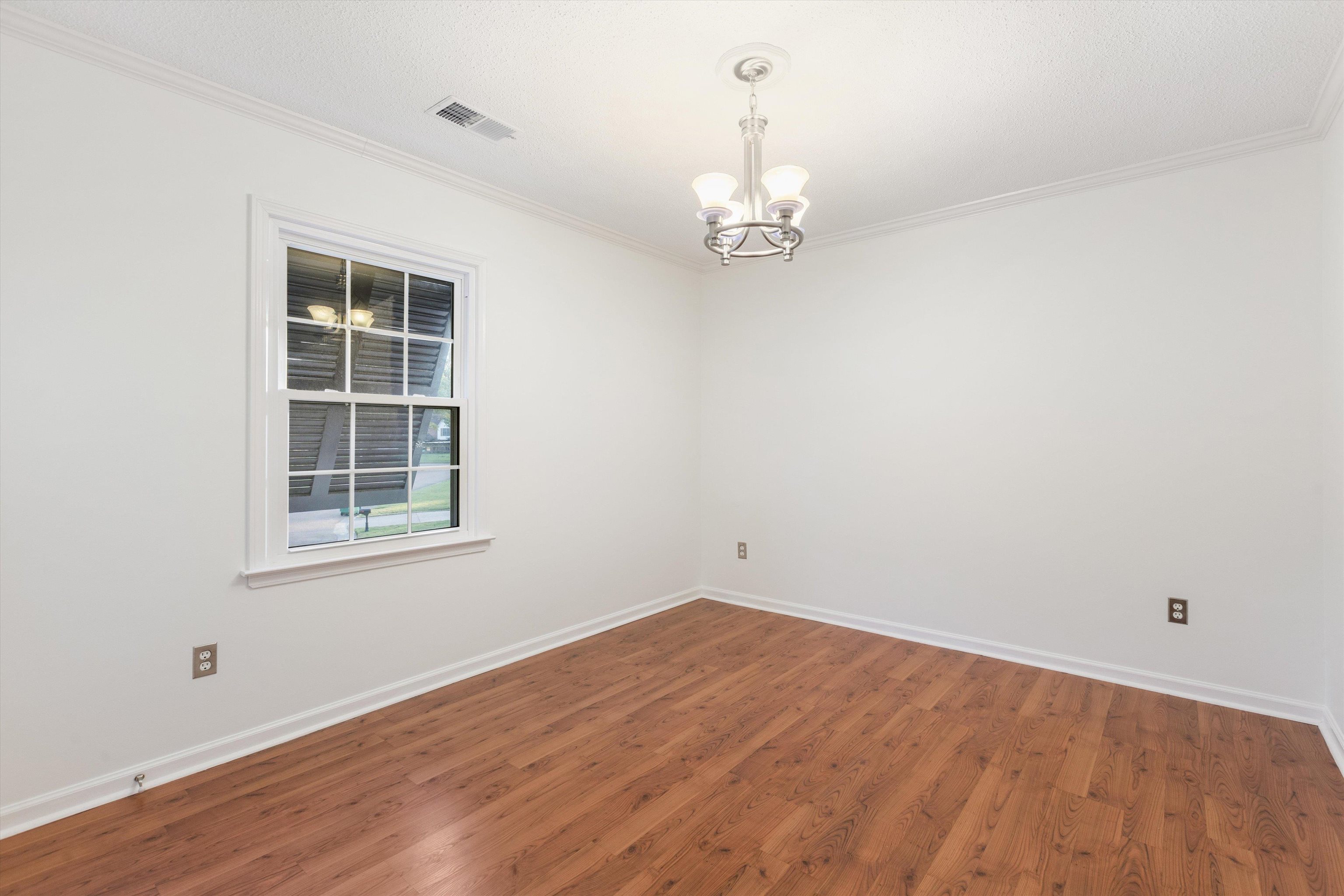 2nd Bedroom with an inviting chandelier, ornamental molding, and hardwood / wood-style flooring