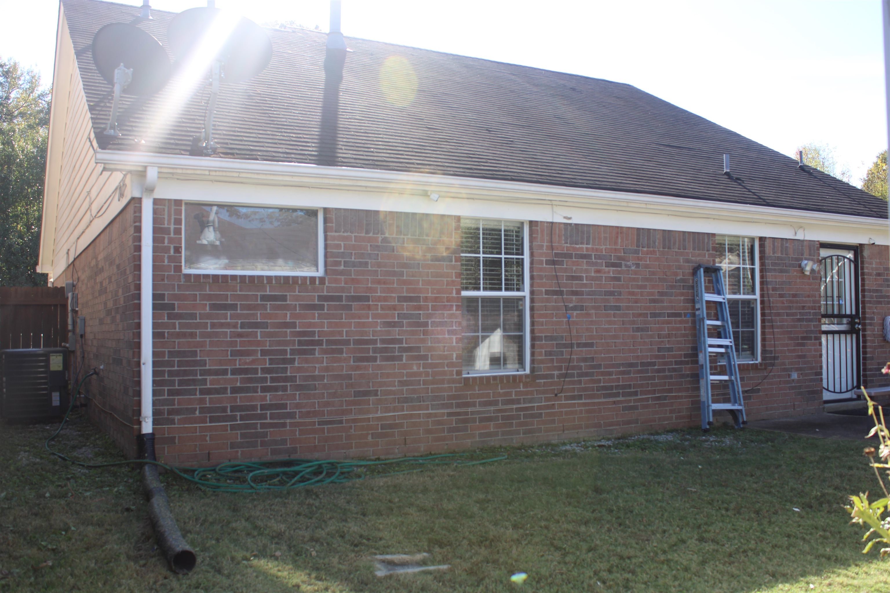 View of side of home featuring a lawn and central AC