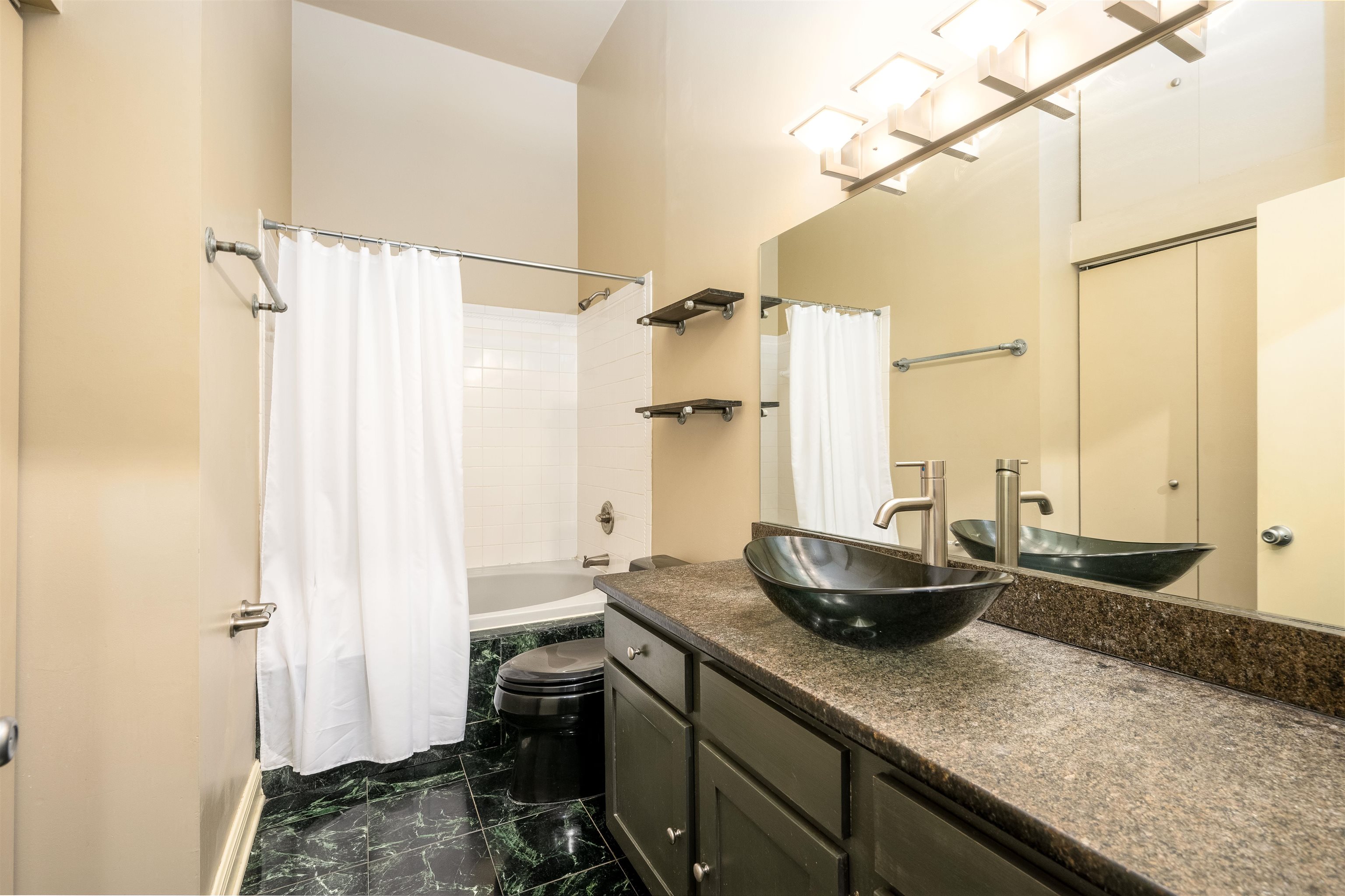 Full bathroom with shower / bath combination with curtain, toilet, and vanity