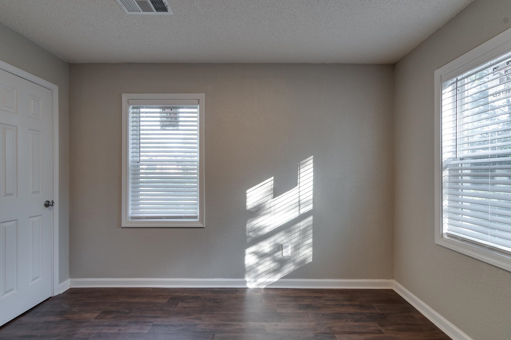 Empty room featuring a textured ceiling and dark hardwood / wood-style floors