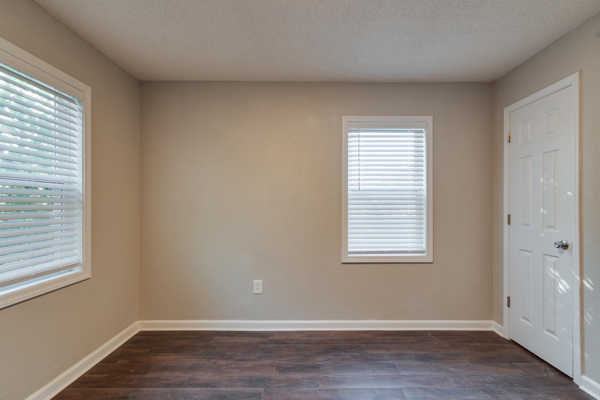 Unfurnished room featuring a textured ceiling and dark hardwood / wood-style floors