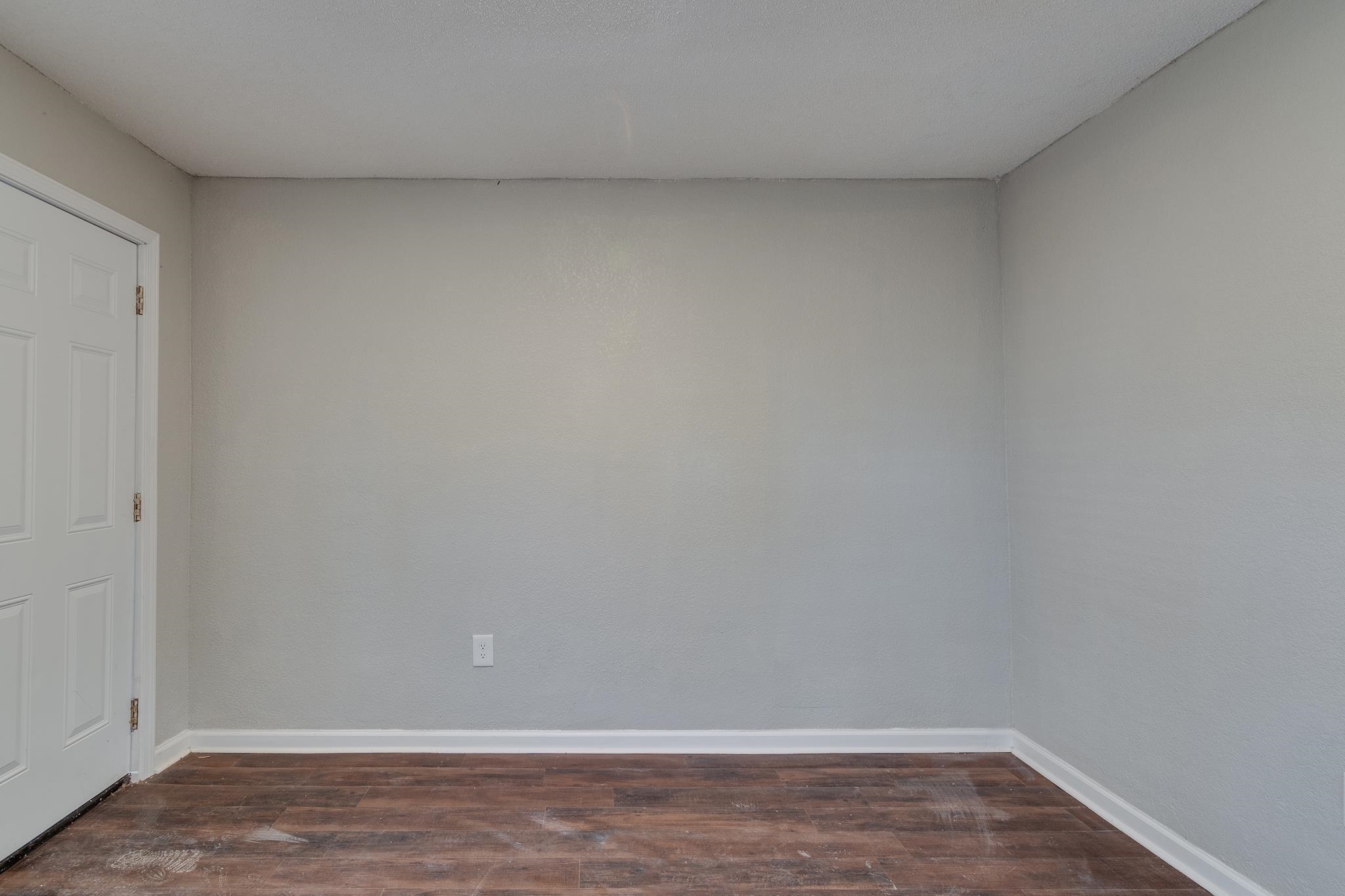 Empty room featuring dark hardwood / wood-style floors