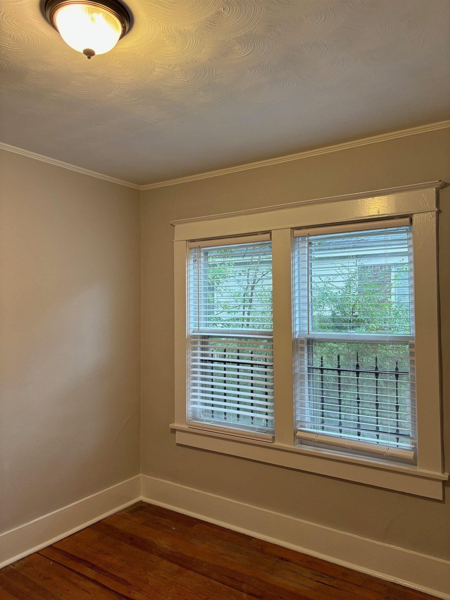 Unfurnished room with hardwood / wood-style floors and crown molding