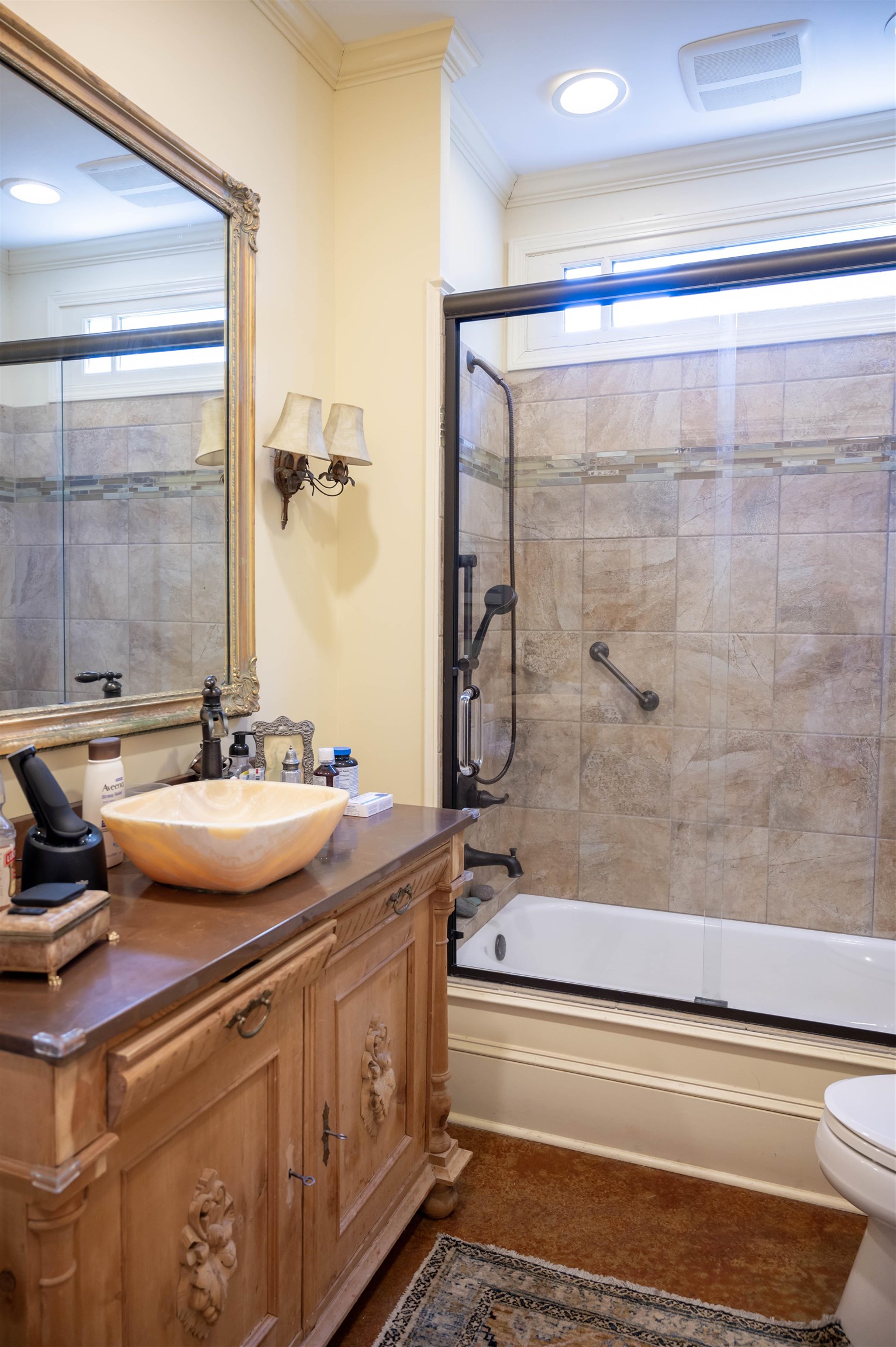 This second primary bath has a shower/tub combo with sliding doors and beautiful cabinetry.