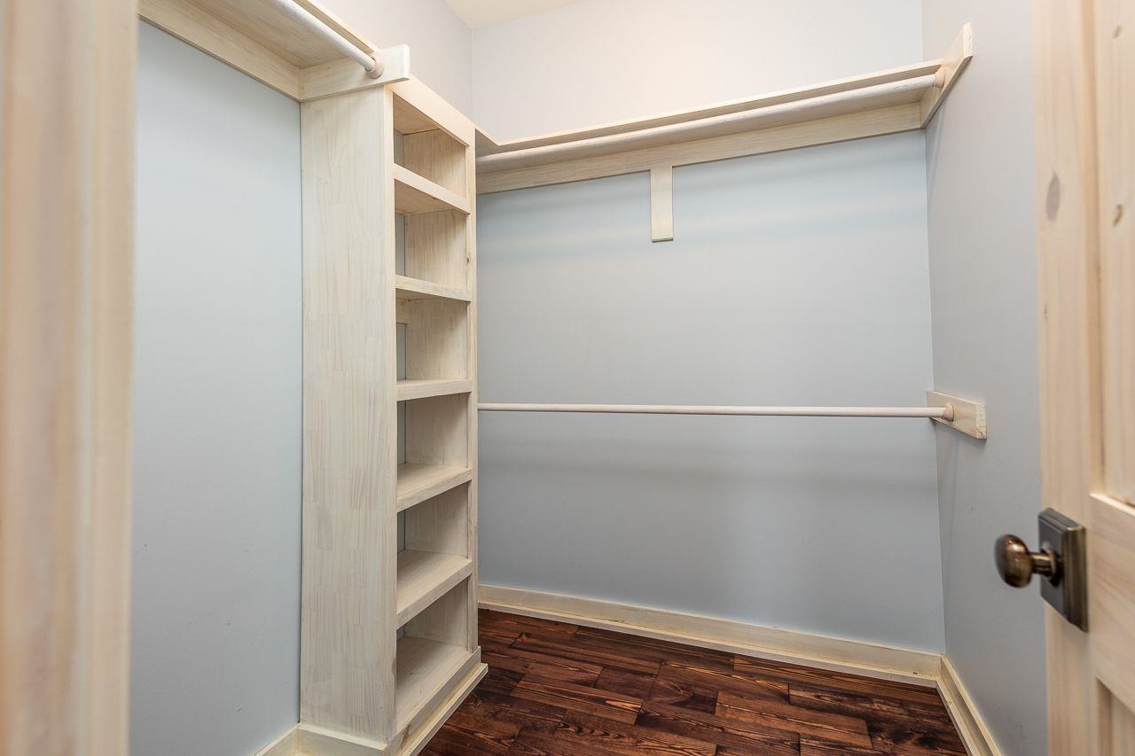 Spacious closet featuring Built-in Shelving and Pine flooring