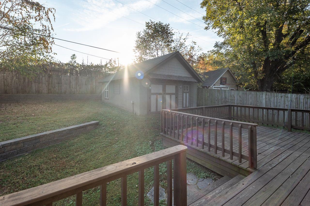 Wooden terrace with a lawn and an outbuilding