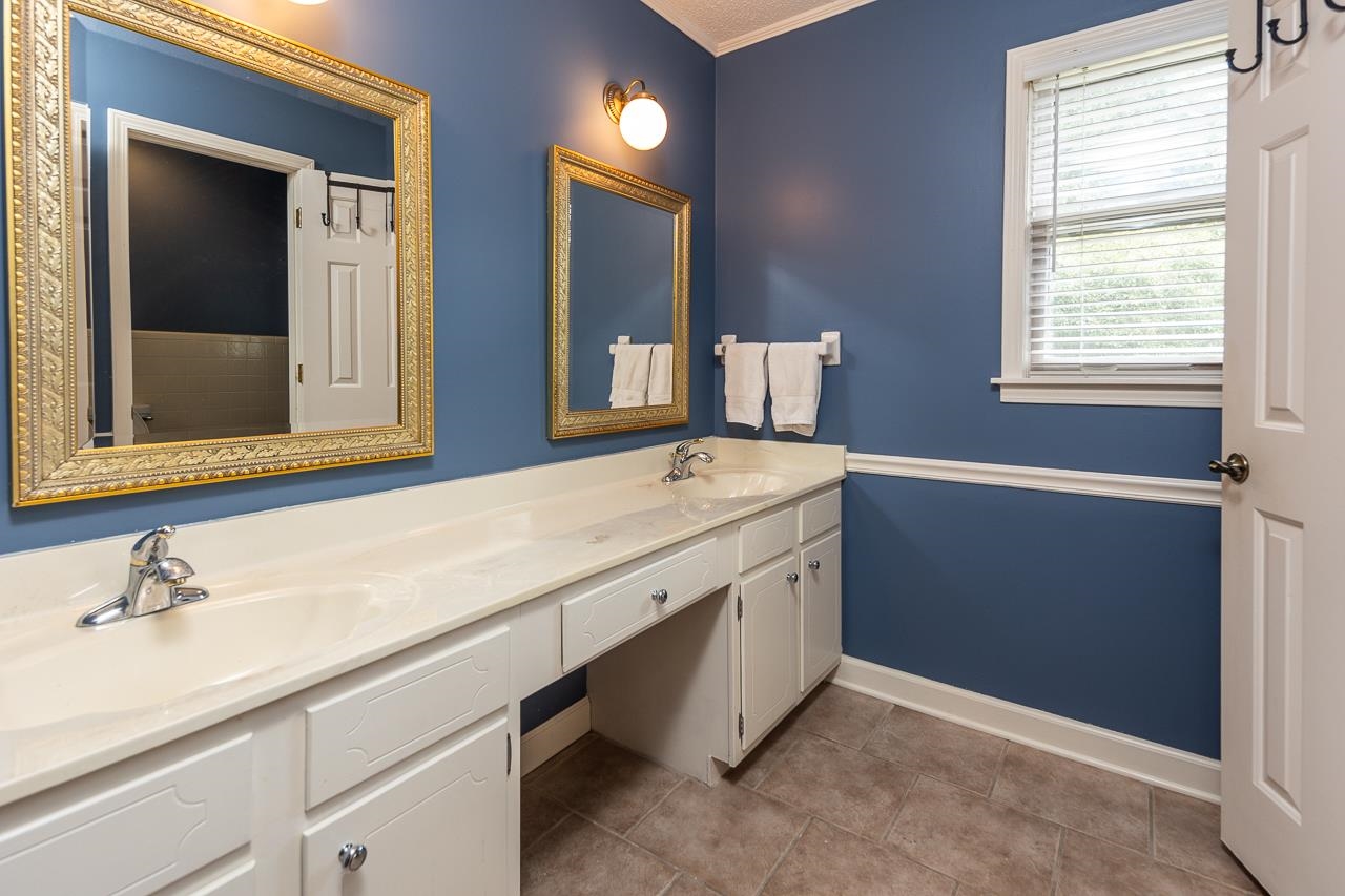 Bathroom with crown molding, vanity, and tile patterned floors