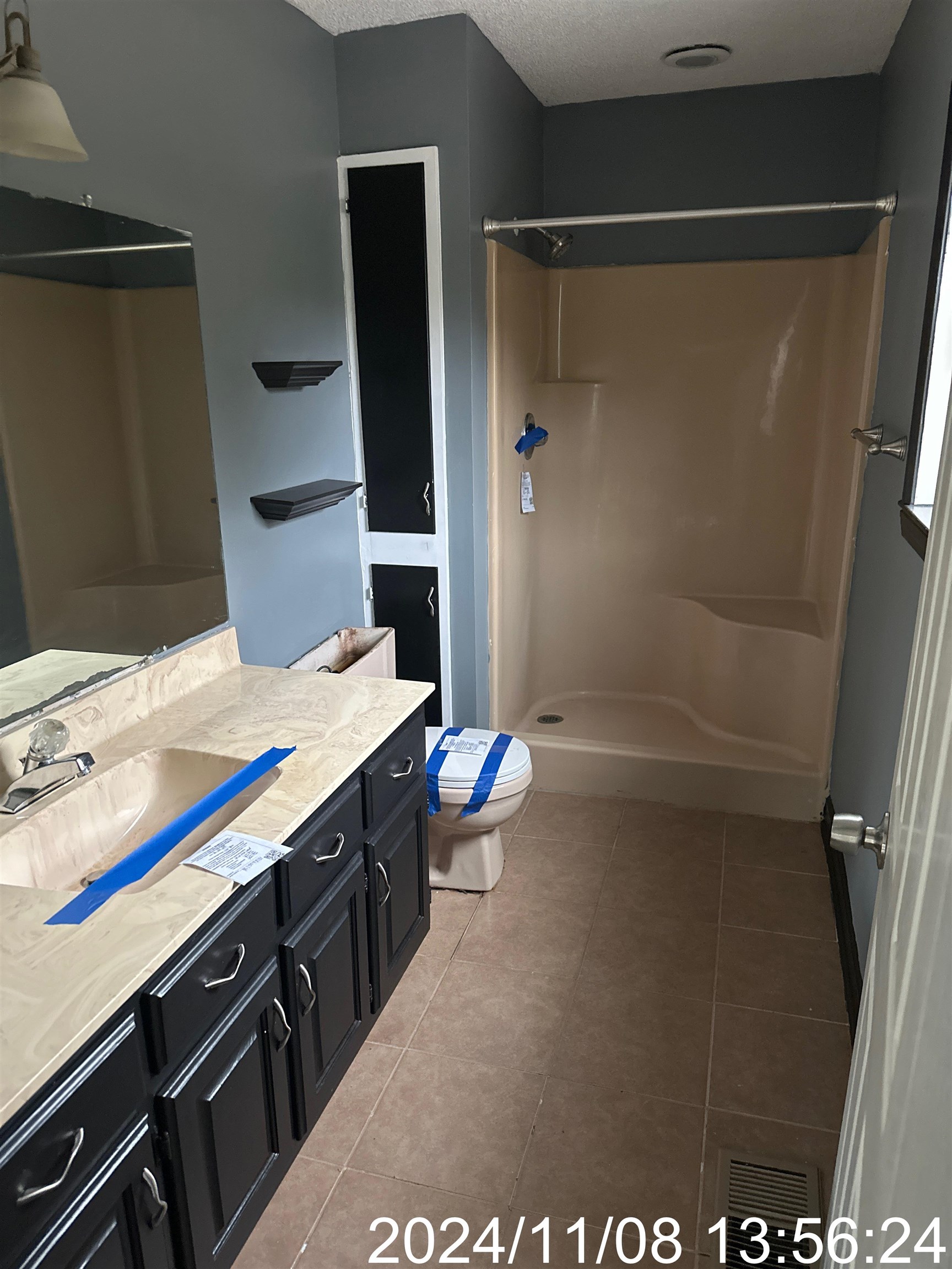 Bathroom featuring a textured ceiling, vanity, a shower, tile patterned floors, and toilet