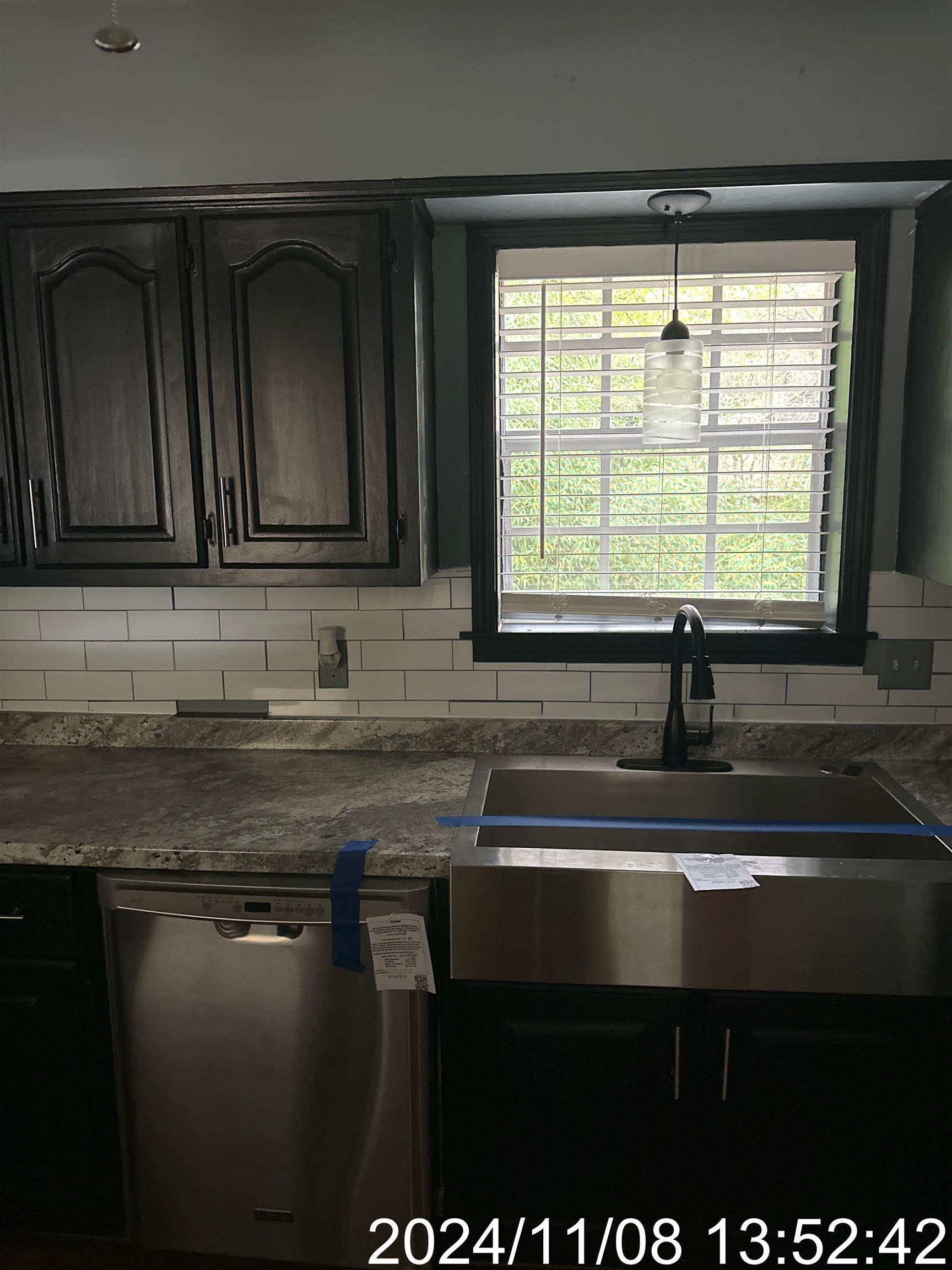 Kitchen featuring stainless steel dishwasher, a healthy amount of sunlight, sink, and tasteful backsplash