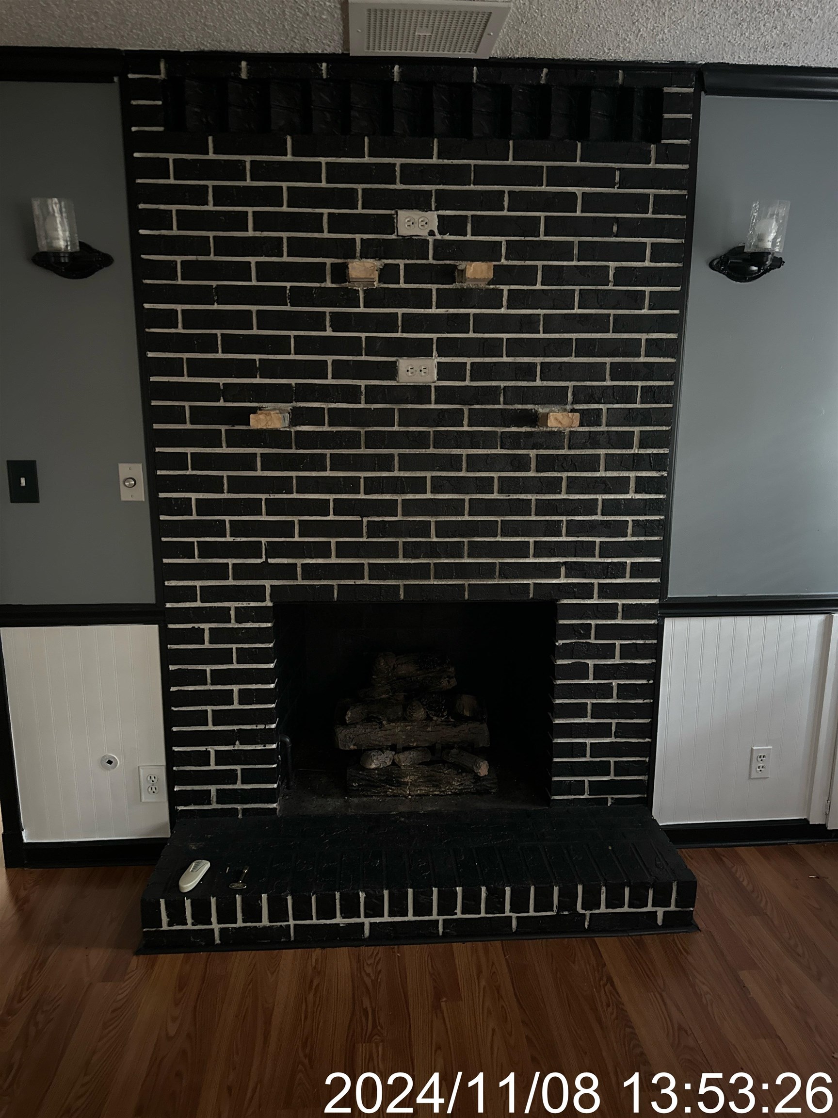 Interior details with a brick fireplace, hardwood / wood-style flooring, and a textured ceiling