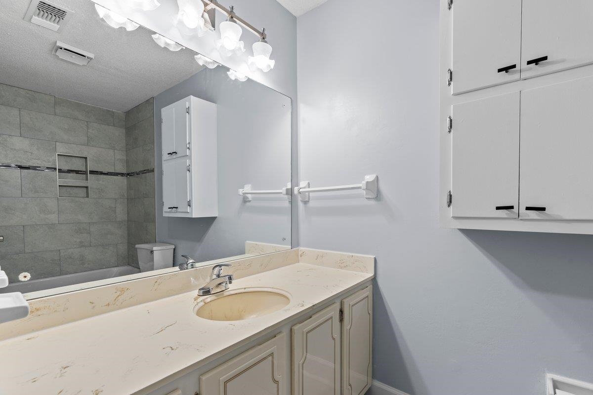 Bathroom featuring vanity, toilet, and a textured ceiling