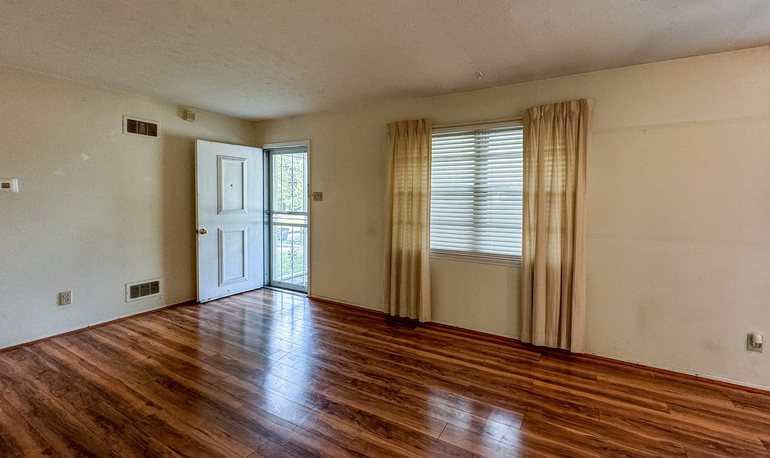 Spare room featuring dark wood-type flooring and a textured ceiling