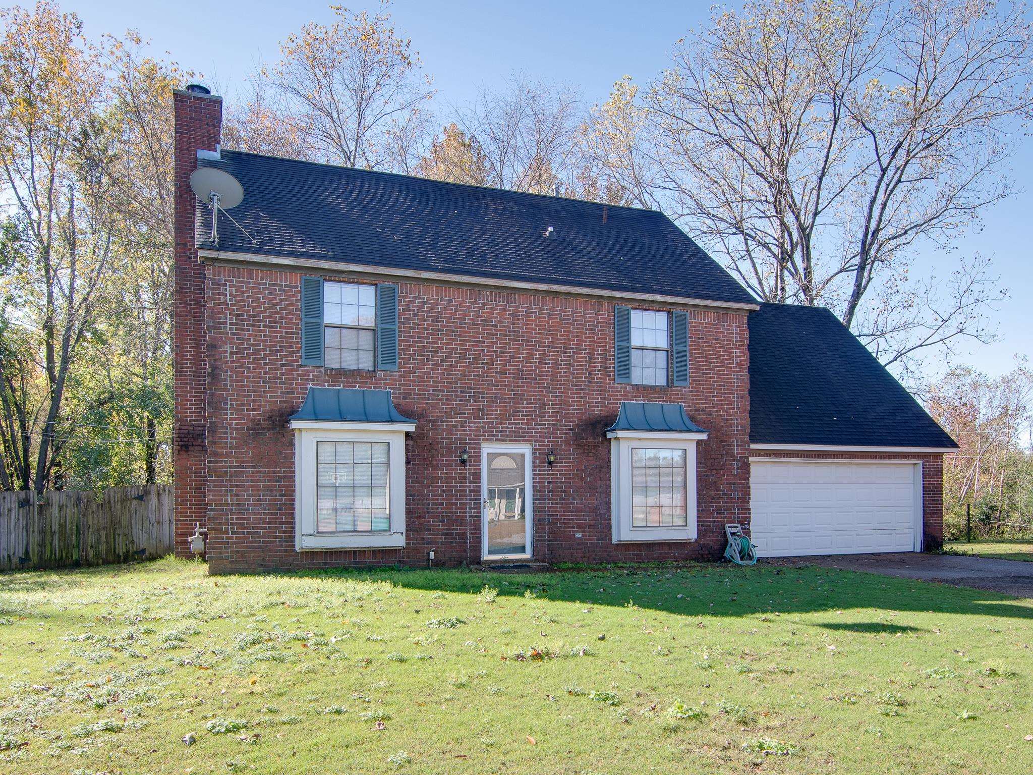 View of front of property featuring a garage and a front yard