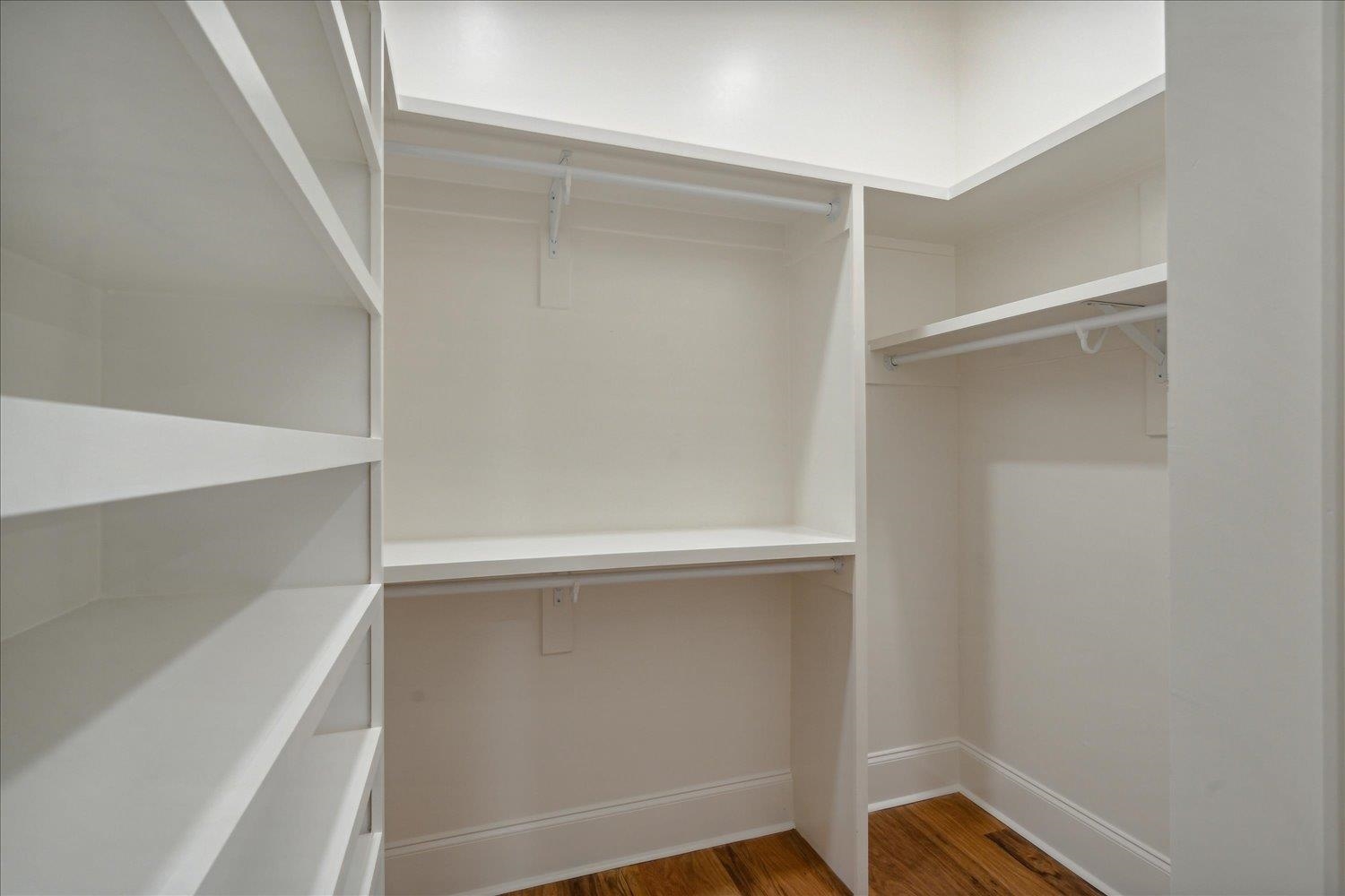 Spacious closet featuring dark hardwood / wood-style floors