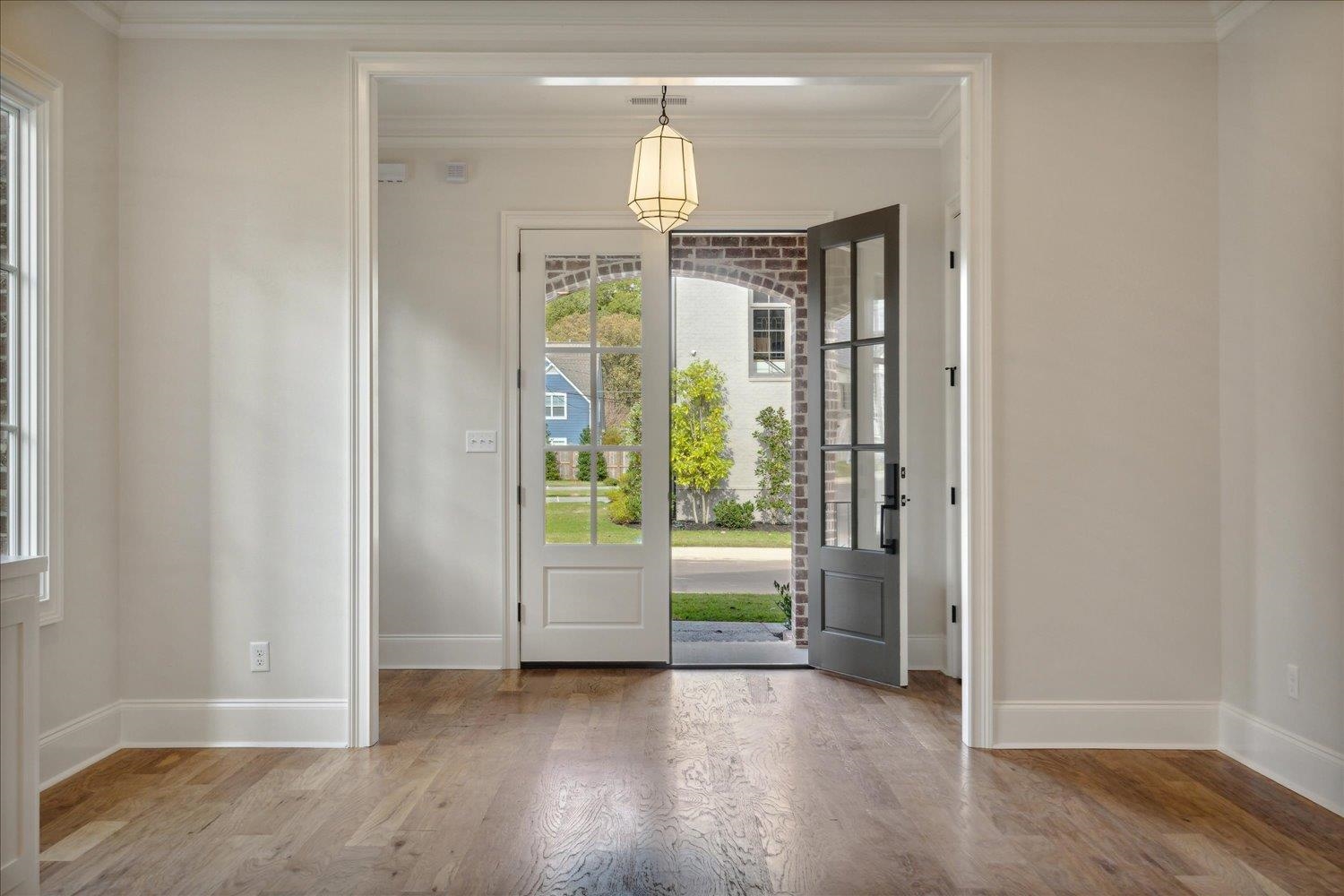 Entryway with hardwood / wood-style flooring and ornamental molding