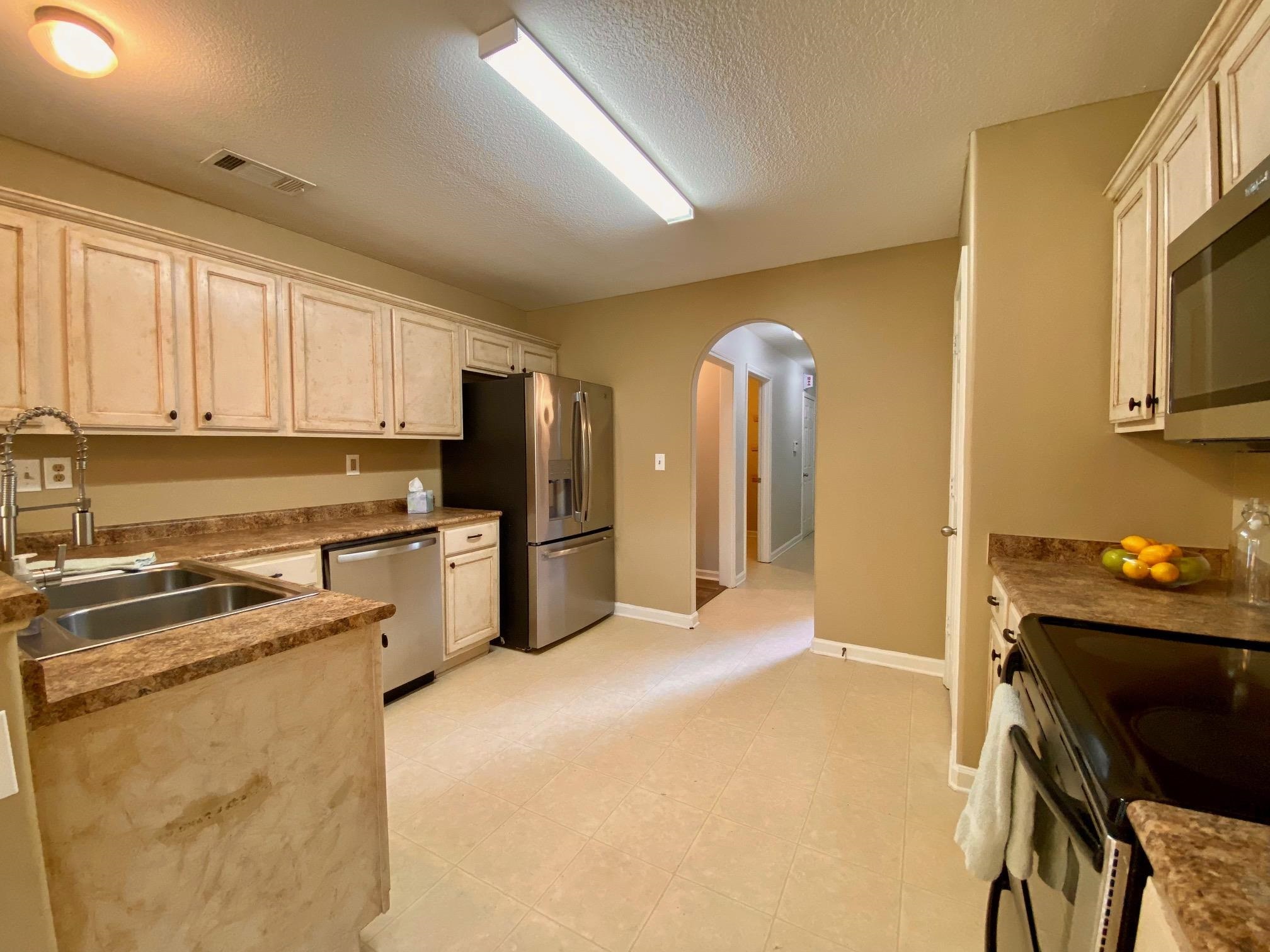 Kitchen with cream cabinets, sink, a textured ceiling, and appliances with stainless steel finishes