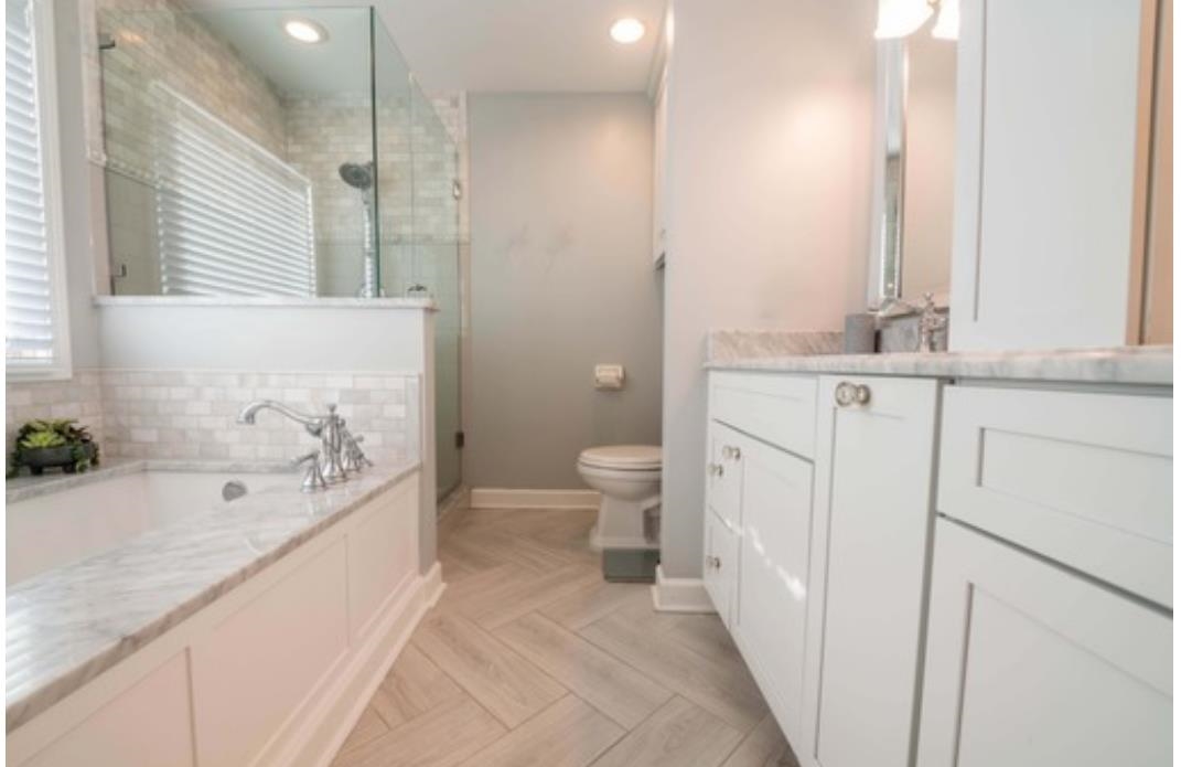 Full bathroom with parquet floors, plus walk in shower, vanity, and toilet