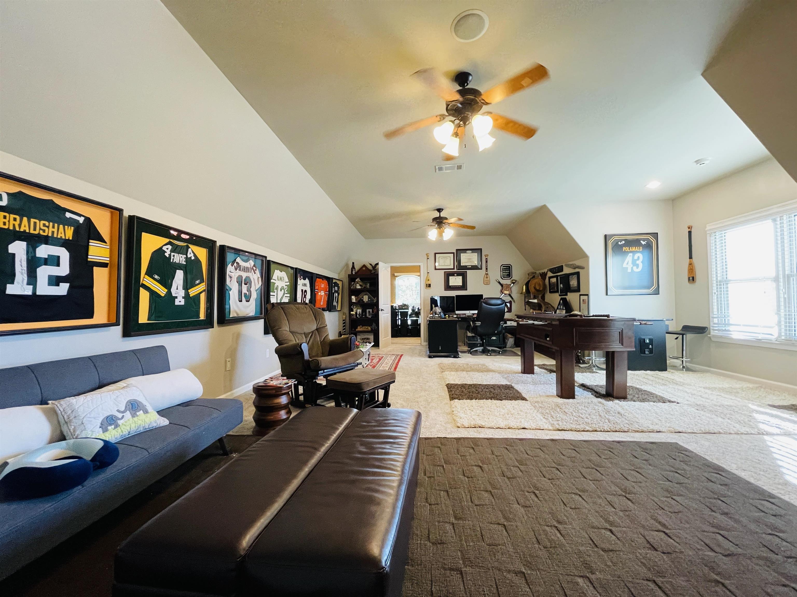 Carpeted office featuring ceiling fan and lofted ceiling