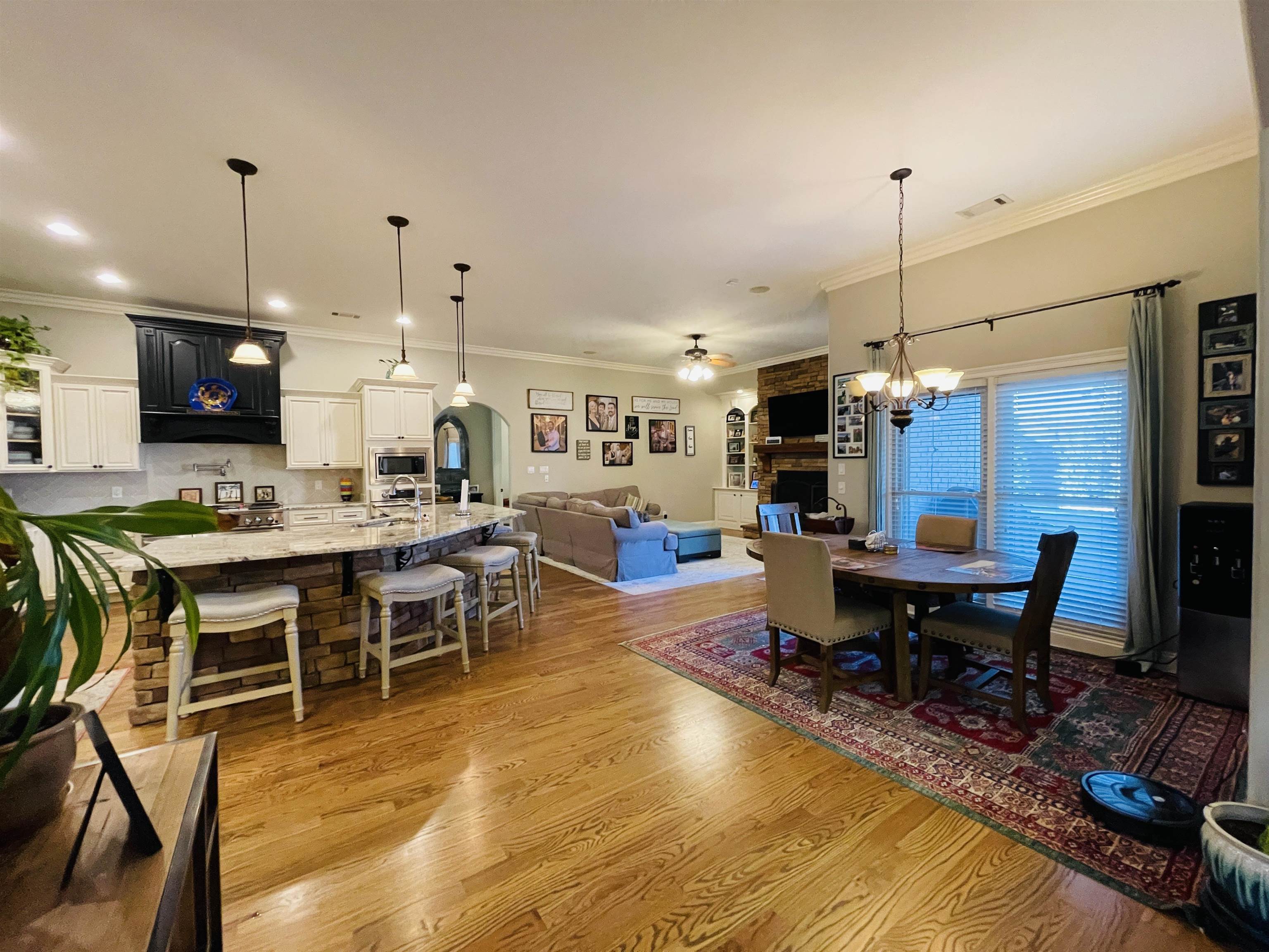 Dining area featuring crown molding, a fireplace, and light wood-type flooring