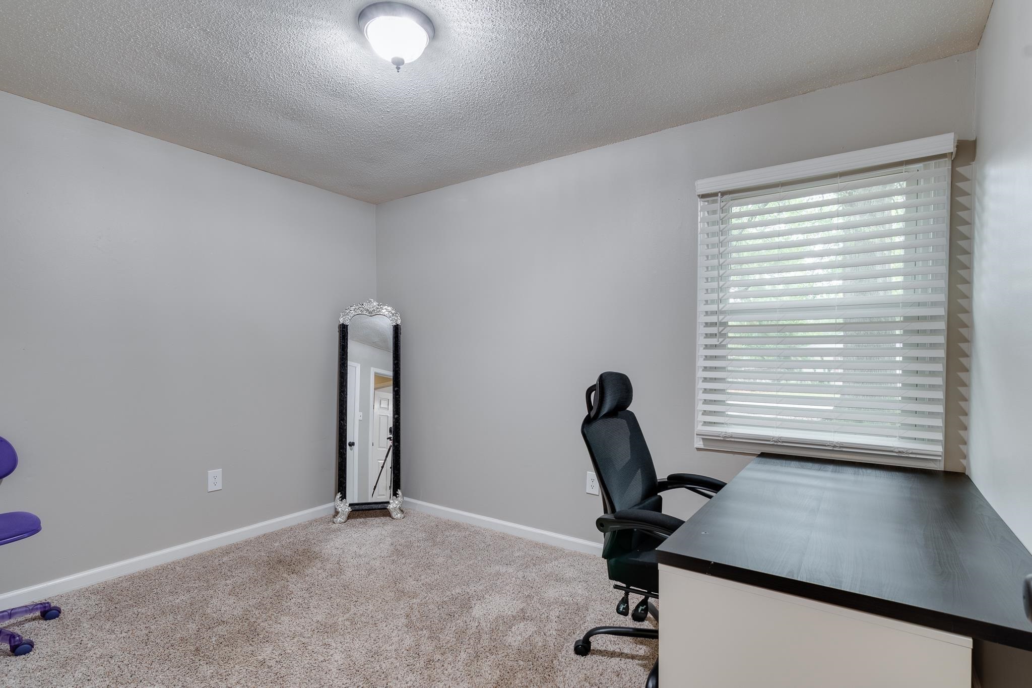 Unfurnished office featuring carpet and a textured ceiling