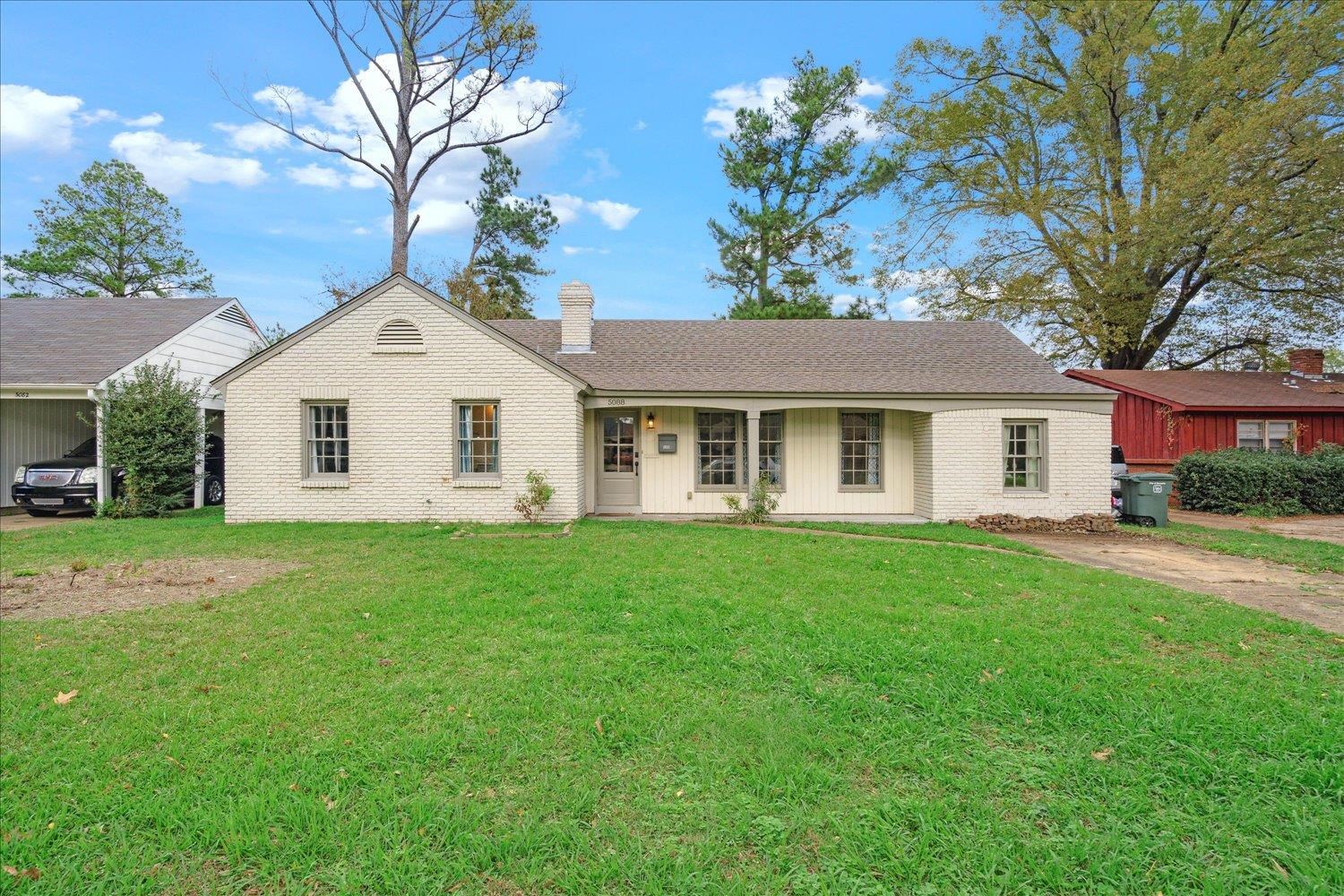Ranch-style home featuring a front lawn