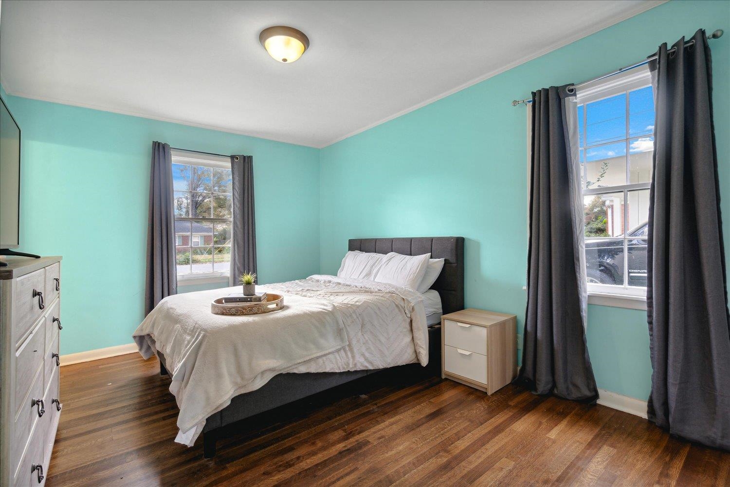 Bedroom featuring dark wood-type flooring and ornamental molding