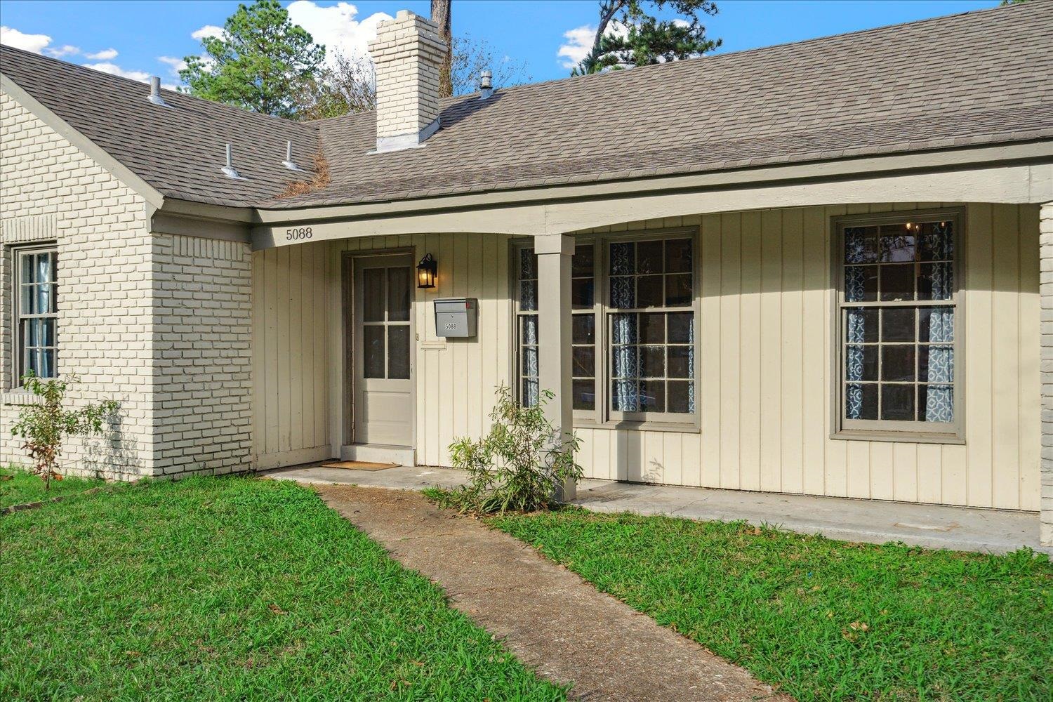 Entrance to property with a yard and a porch